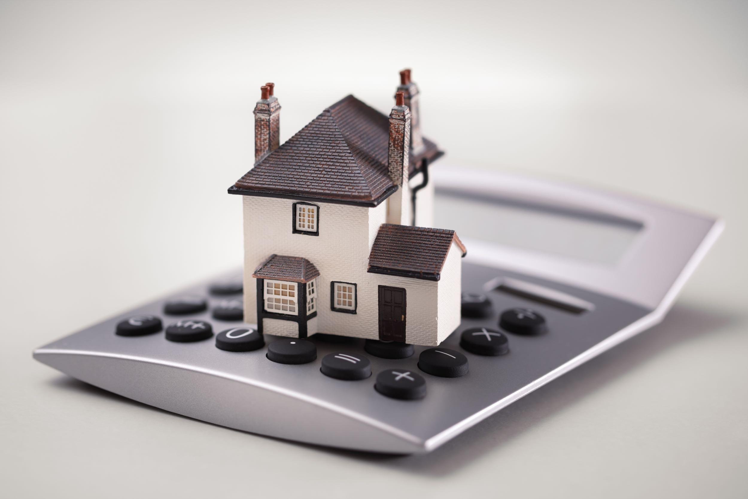 house resting on calculator