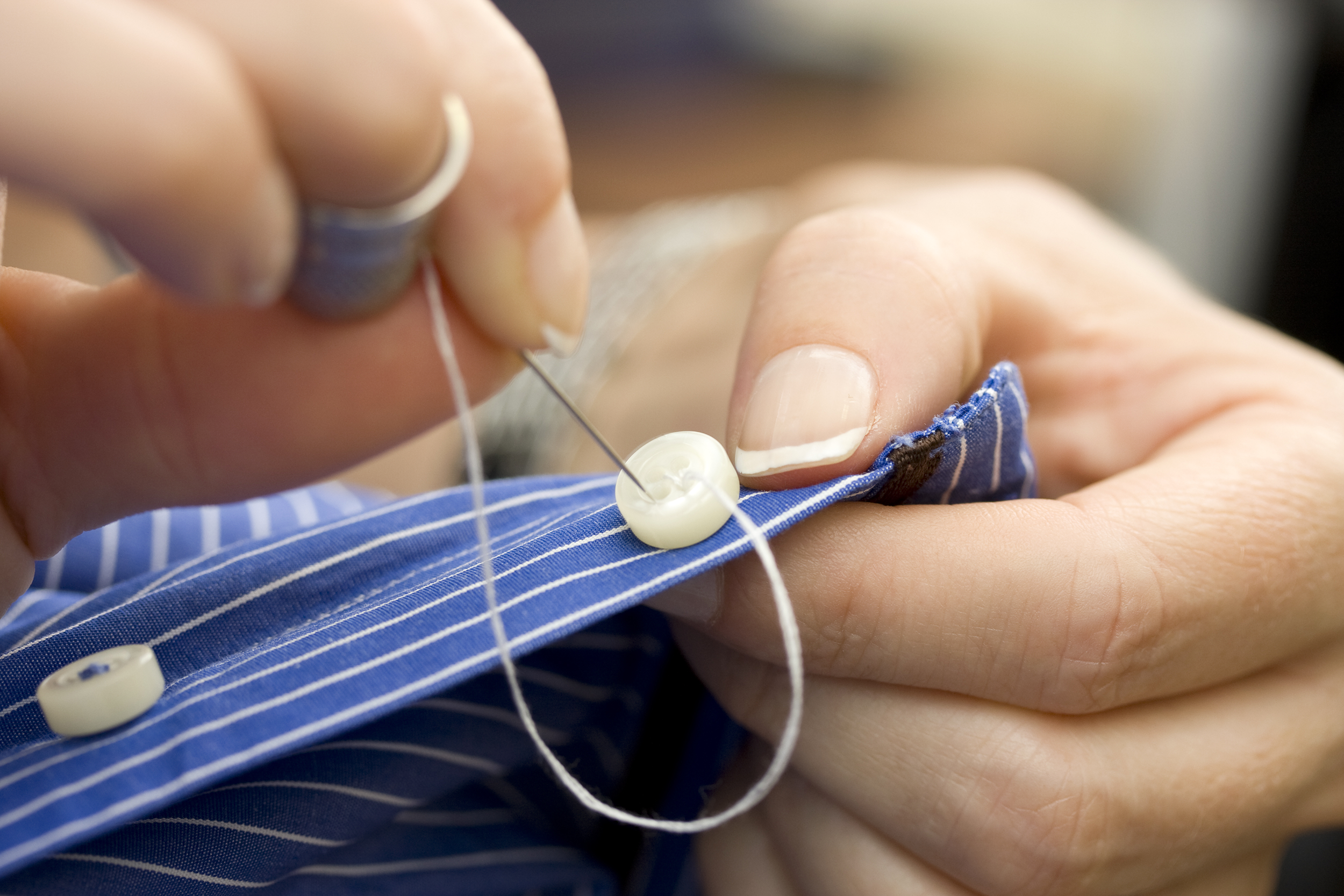 Sewing a button on a shirt