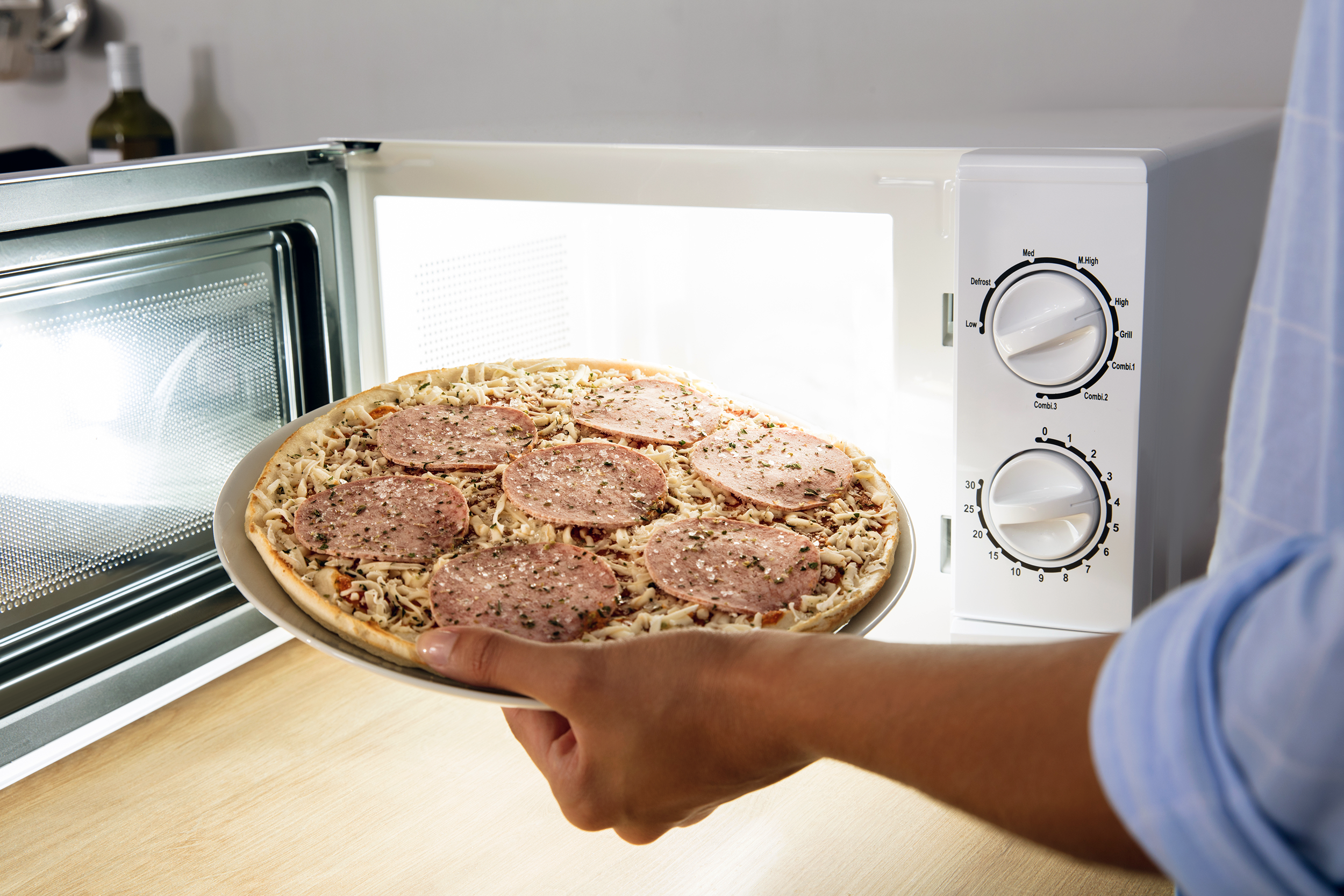 Putting a pizza in the microwave