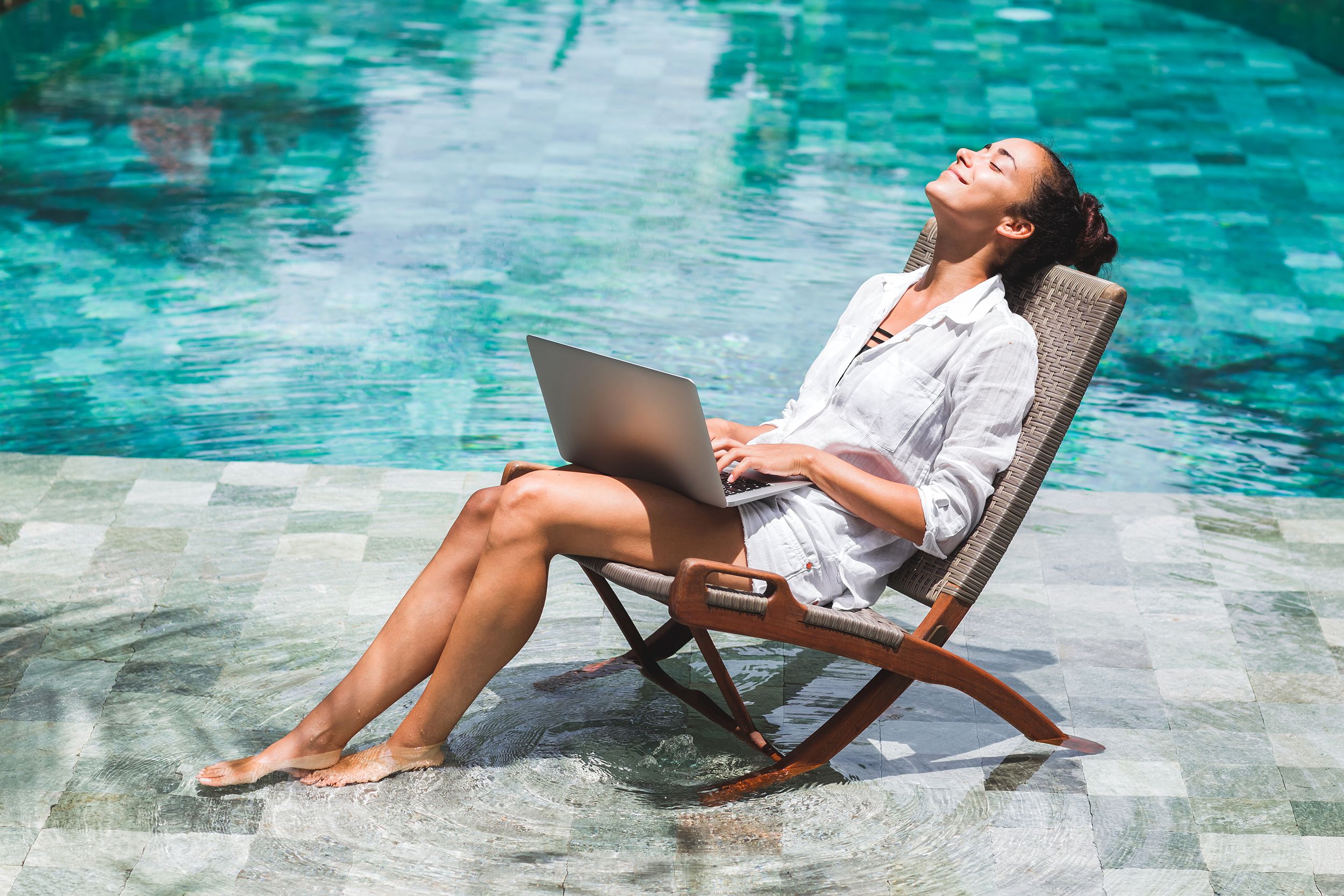 Woman on her laptop in a pool
