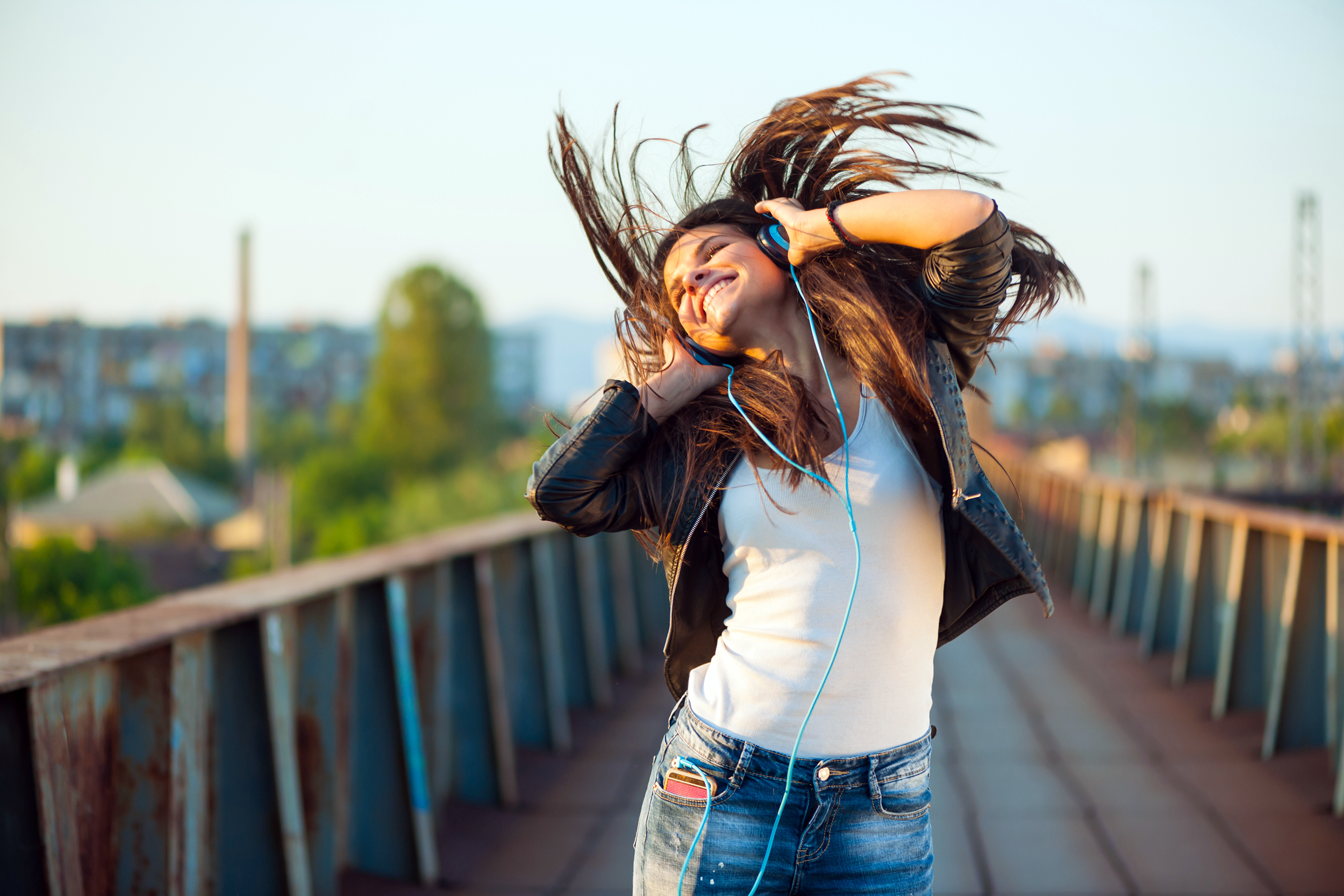 Young teen dancing to music and wearing headphones