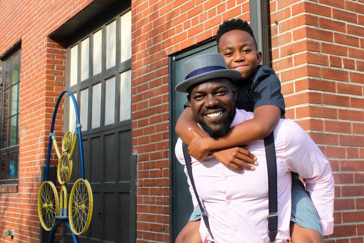 Father smiling with his son on his back