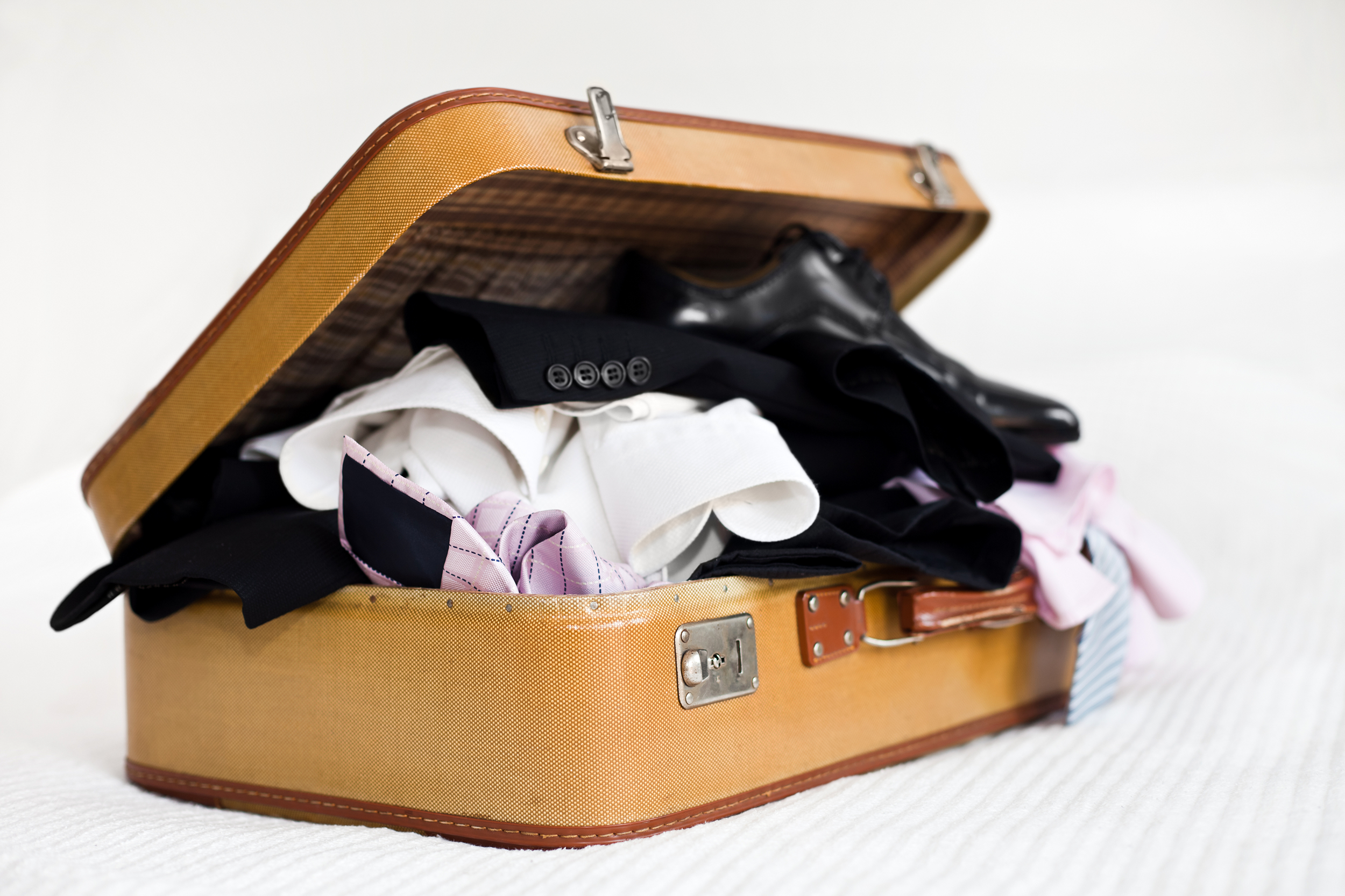 Messy open suitcase with business clothes