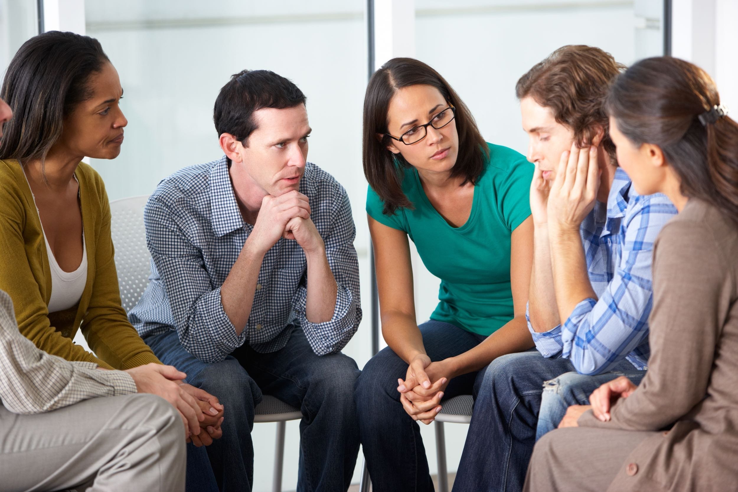people sitting in chairs in a support group
