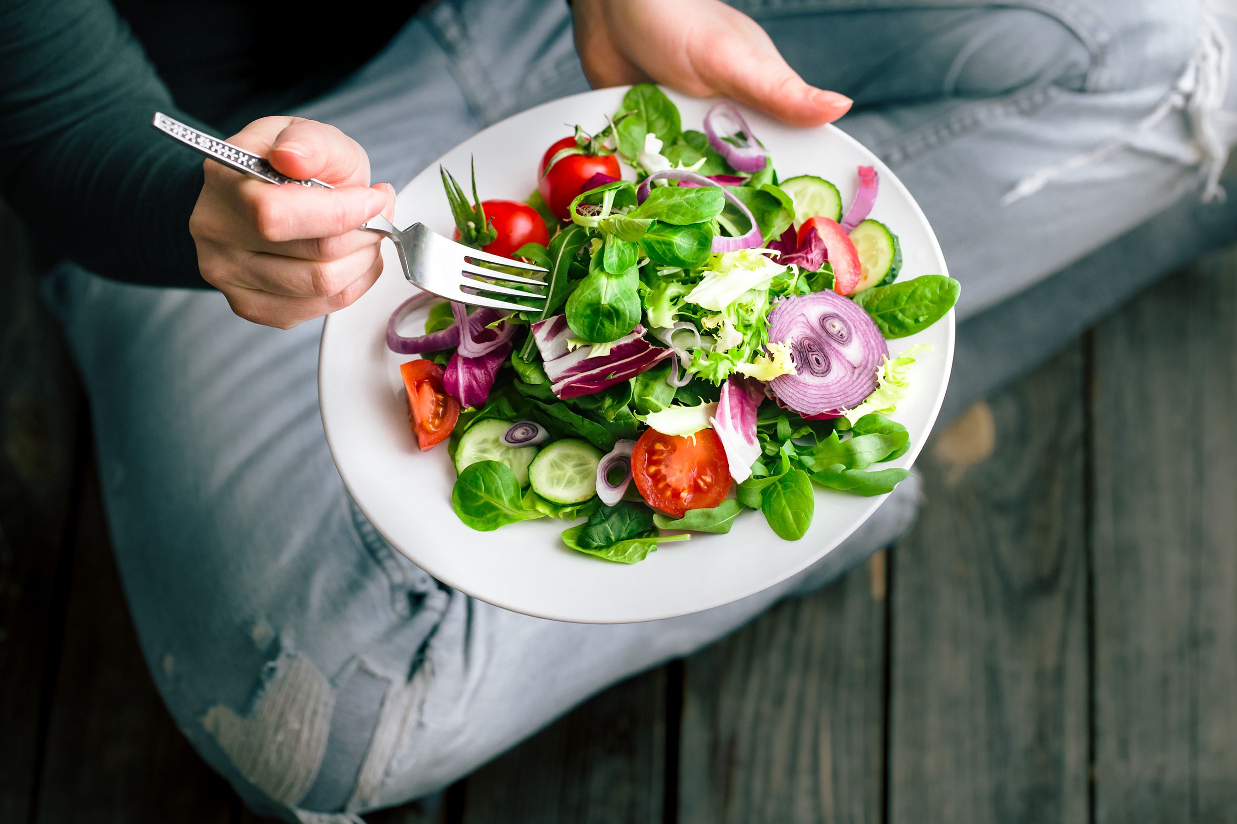 fresh salad in hands view from above