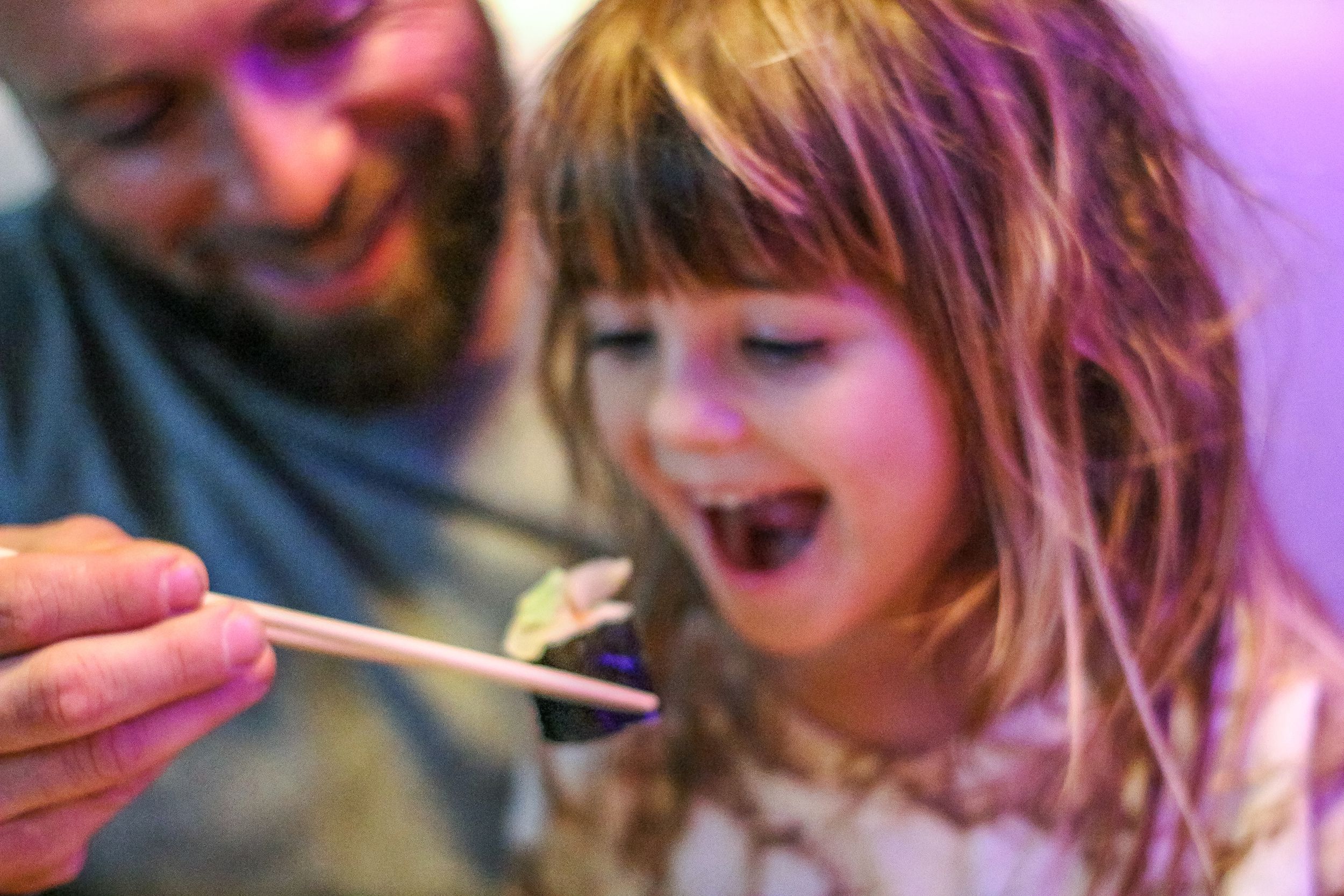 daughter eating sushi with father