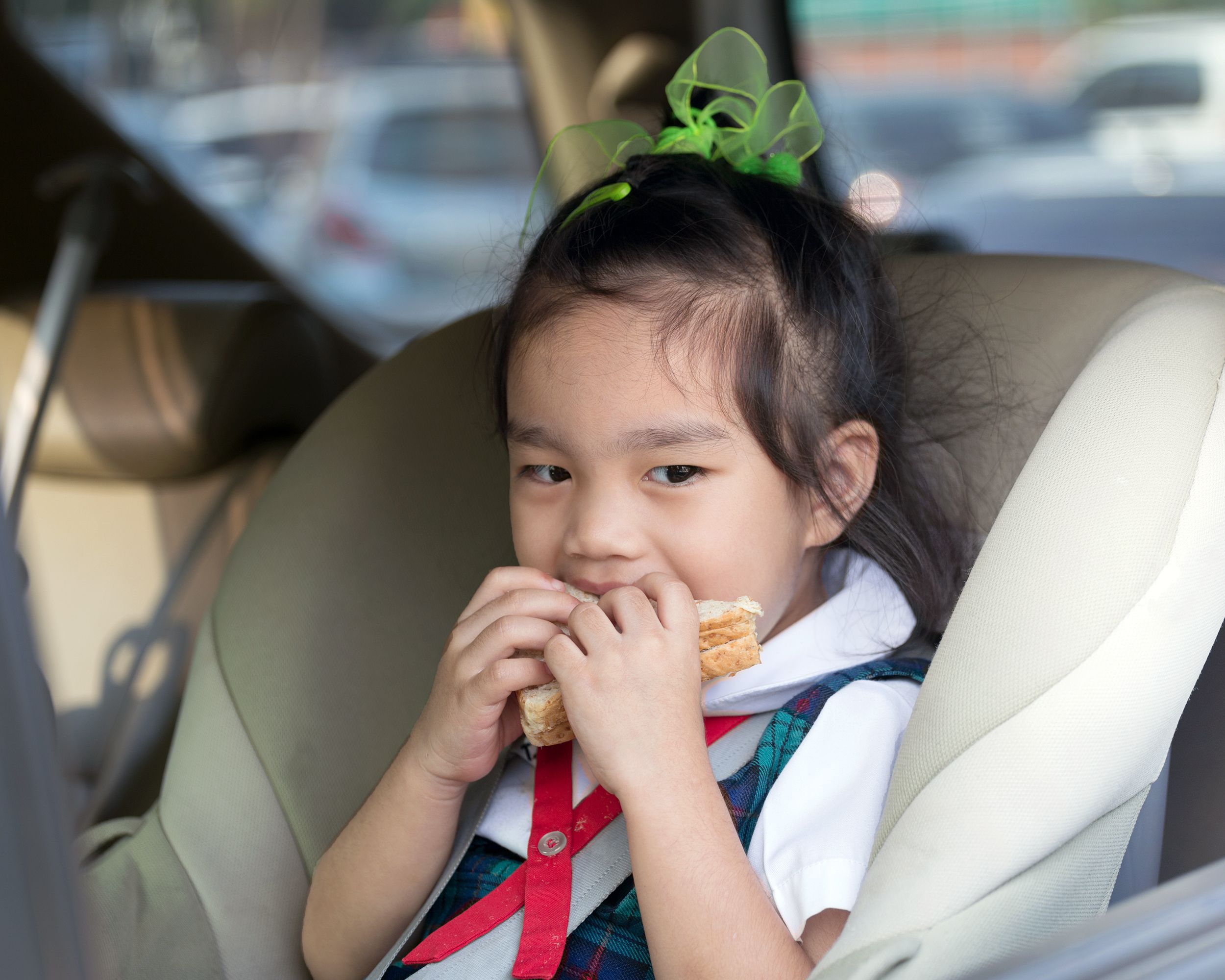 child in car eating sandwich