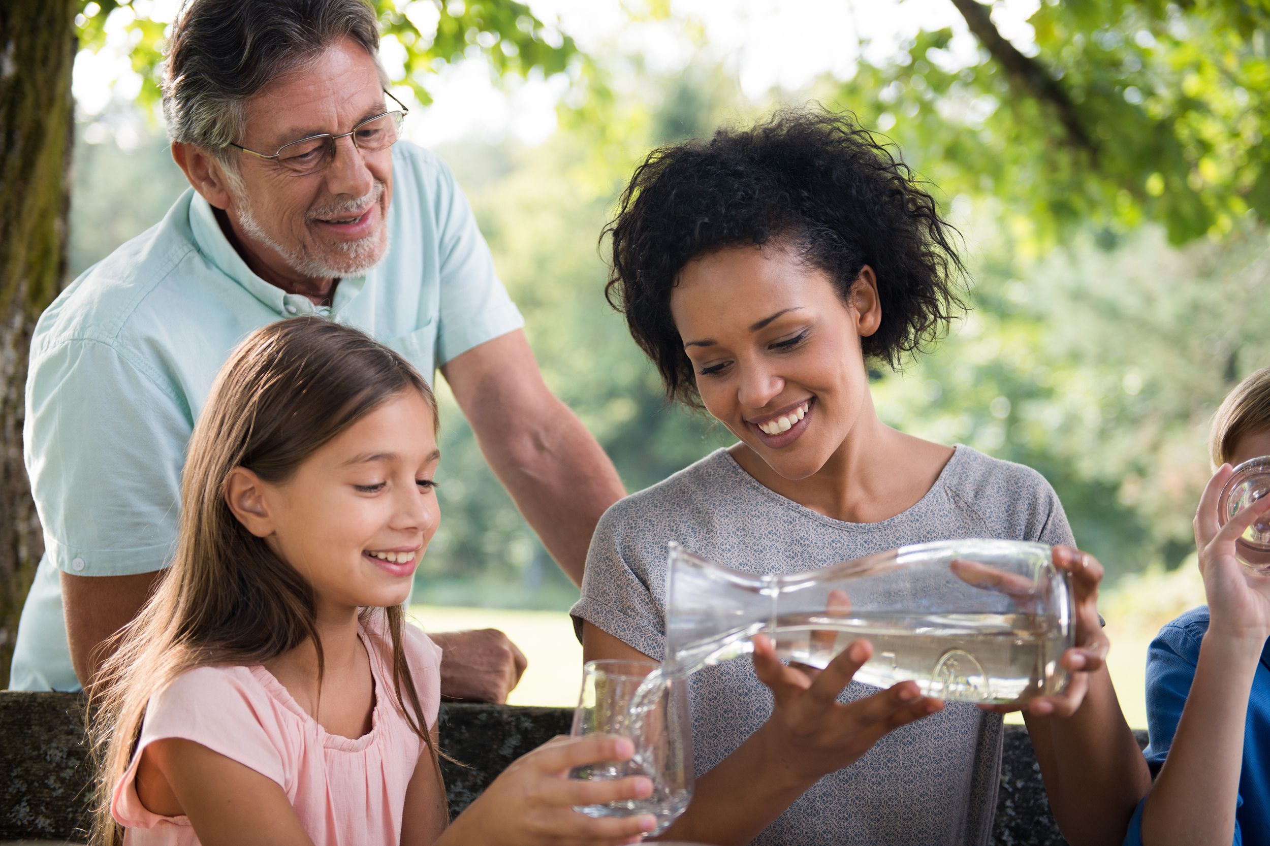 family drinking water in the park