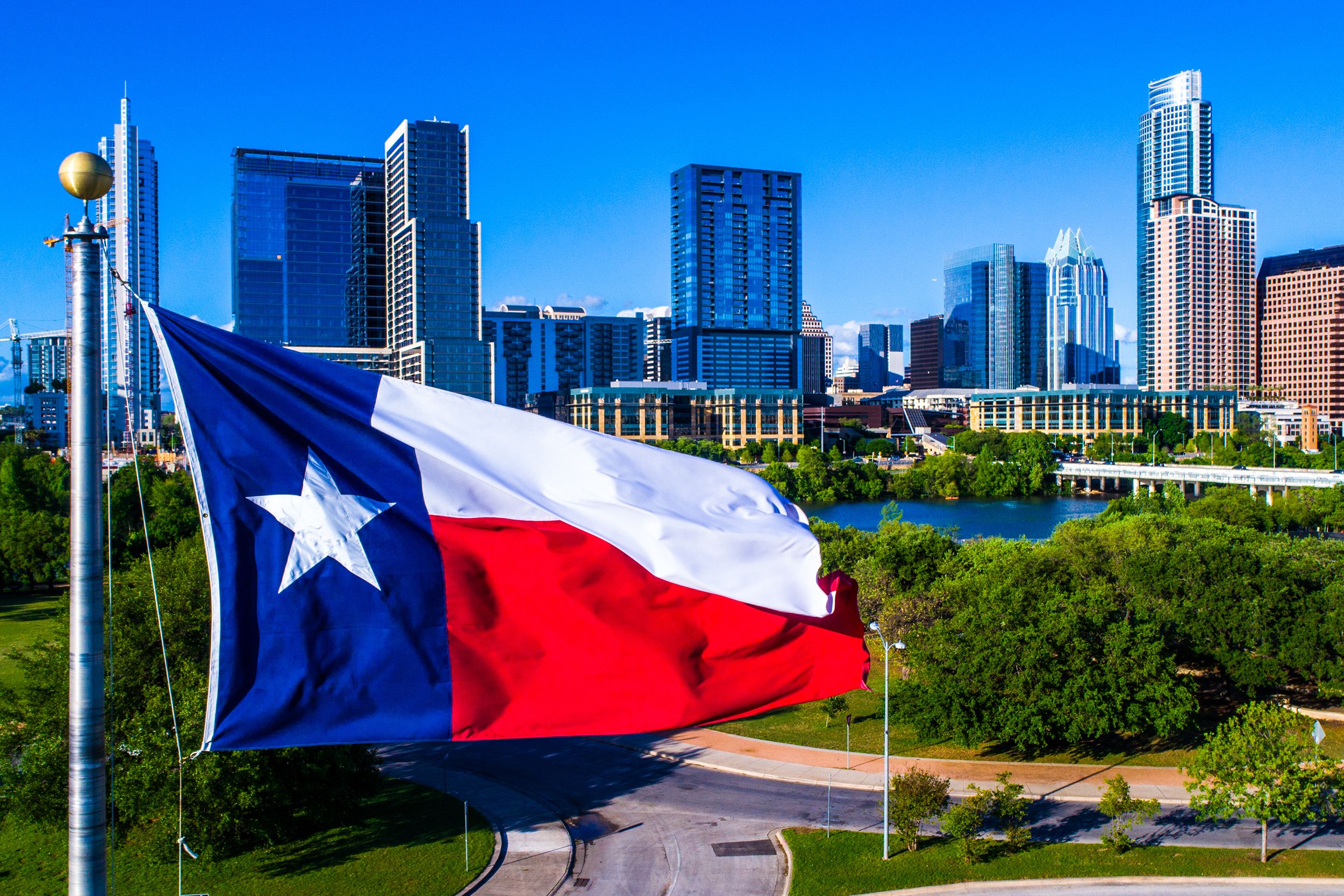 Texas flag flying in front of Austin Texas downtown