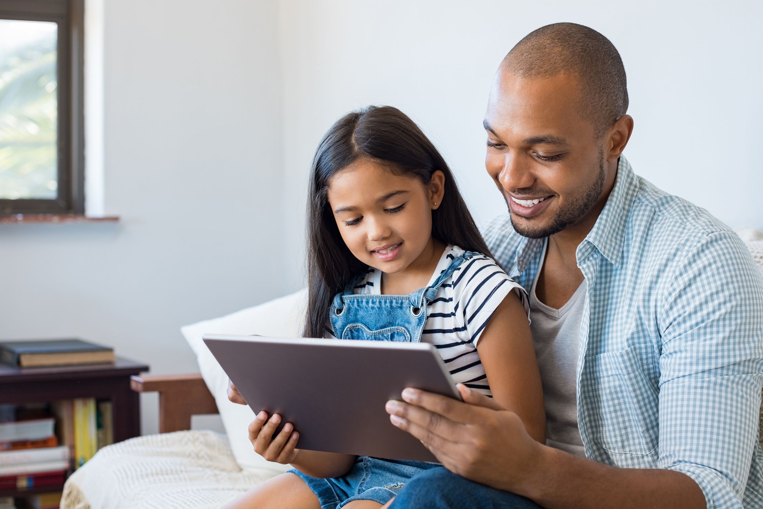 father and daughter using tablet