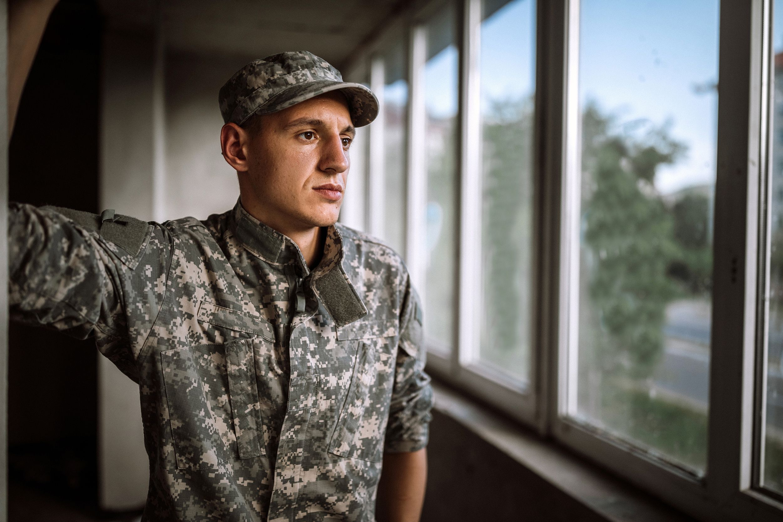 young depressed soldier looking out of window
