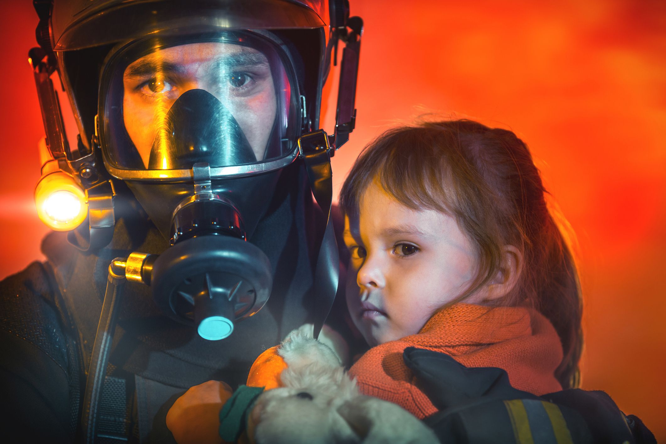 firefighter in rescue gear holding little girl