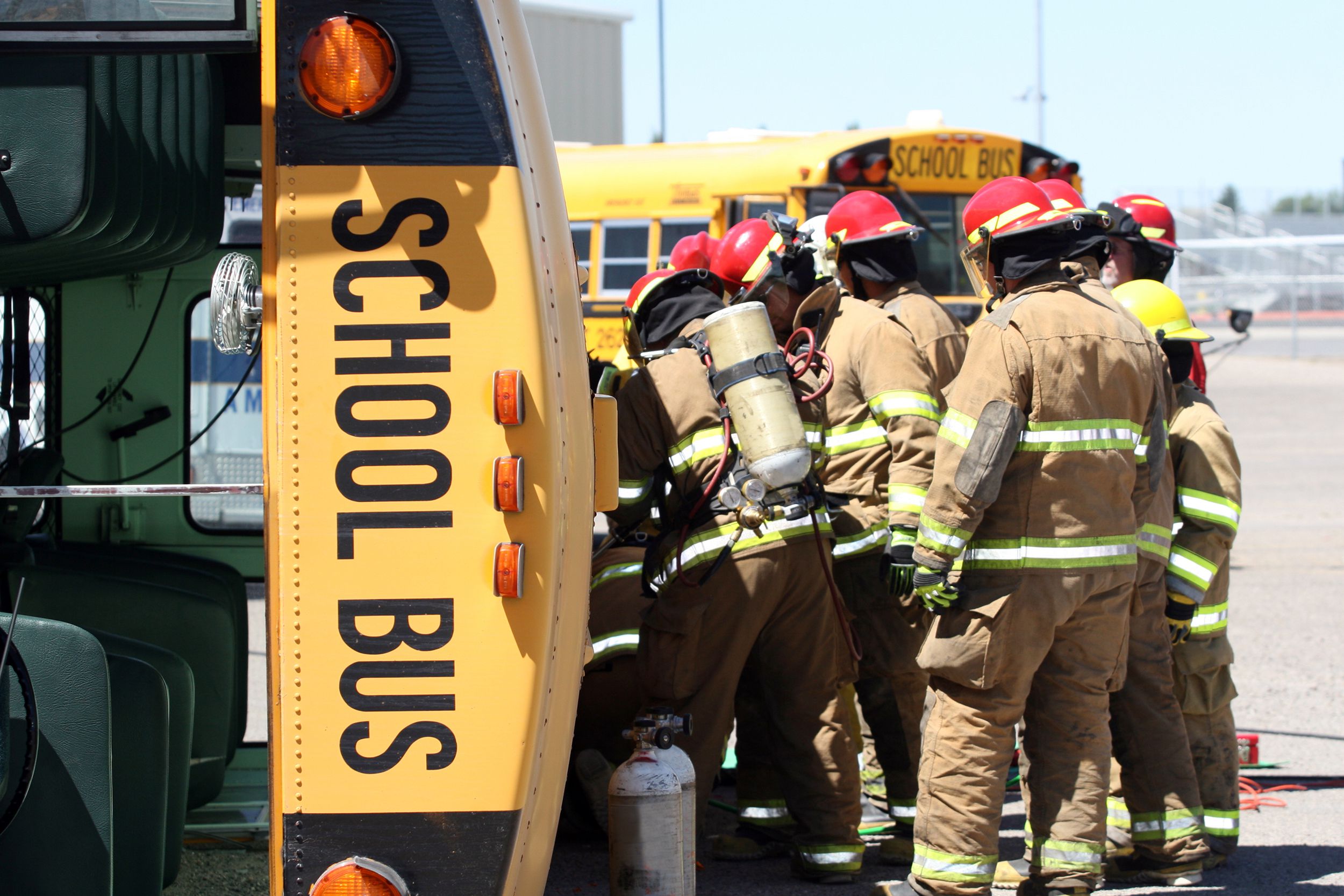 firefighters working on turned-over schoolbus