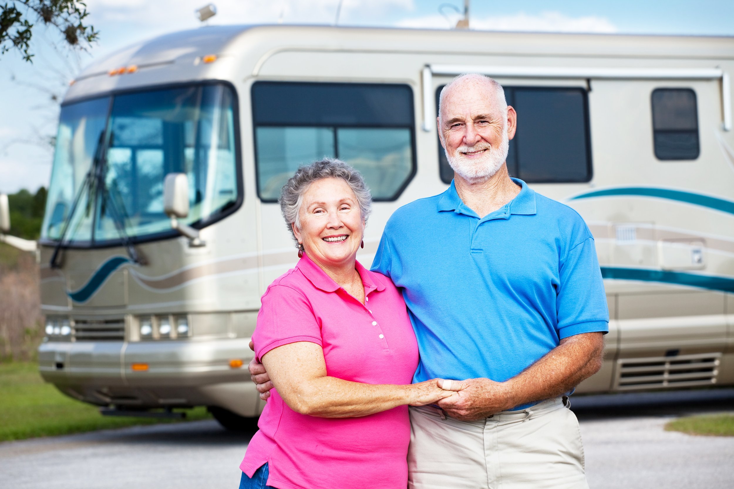 active retired couple with their rv in background