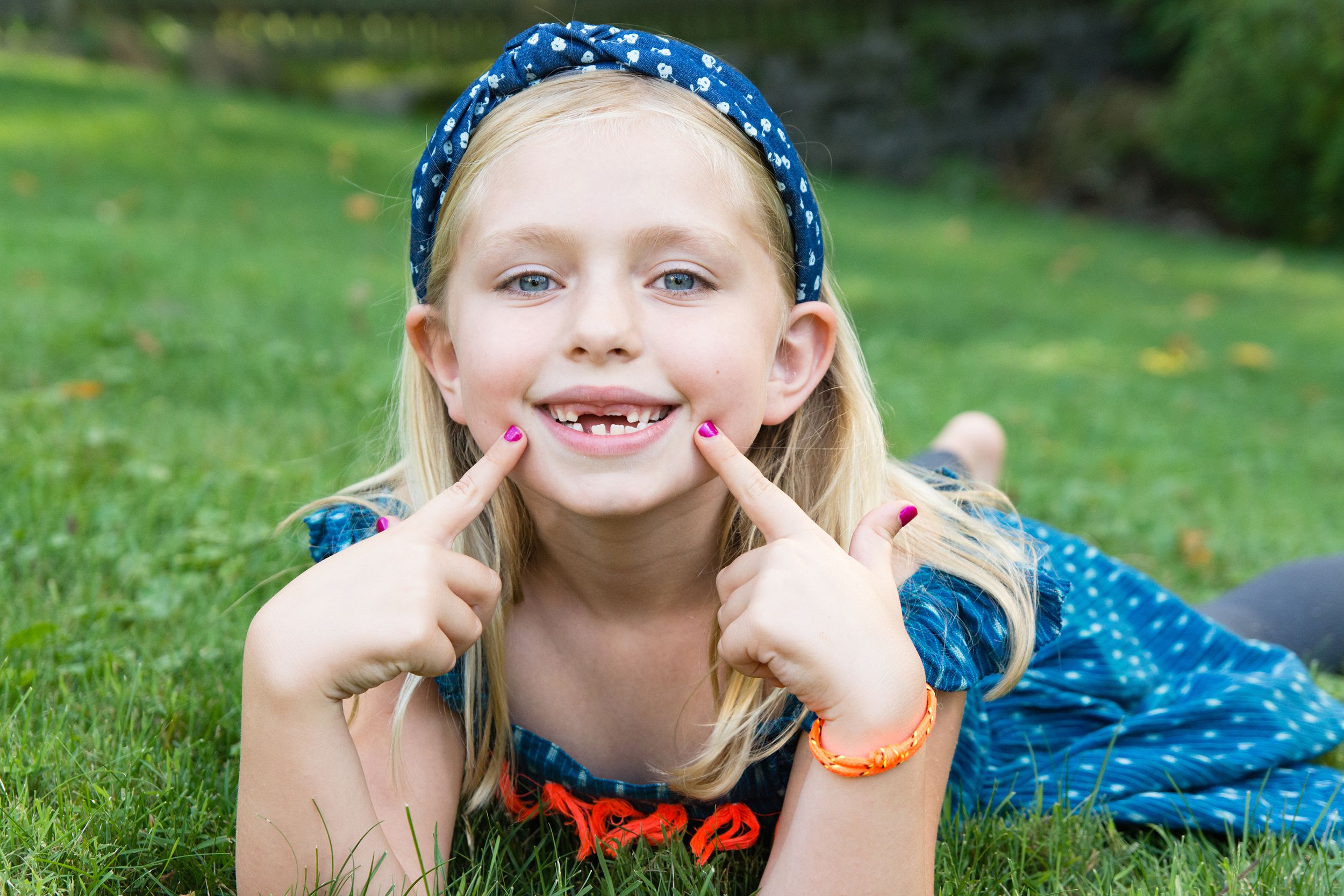 young school age girl showing gap with missing front two teeth