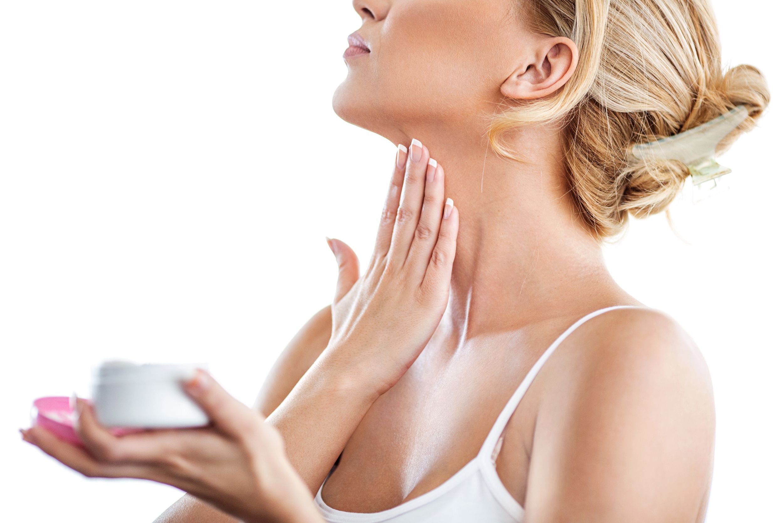 woman putting on lotion on her neck