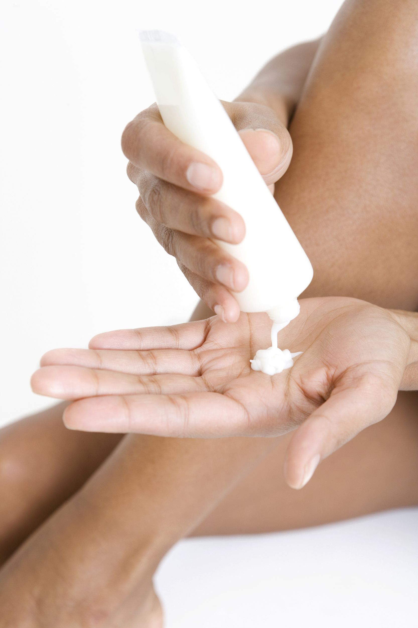 woman squeezing moisturizing lotion from a tube onto her hand