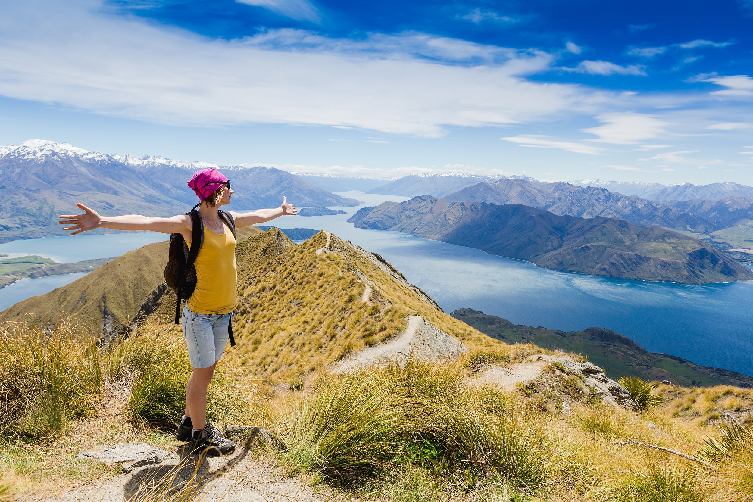 woman traveler with backpack hiking in mountains in New Zealand