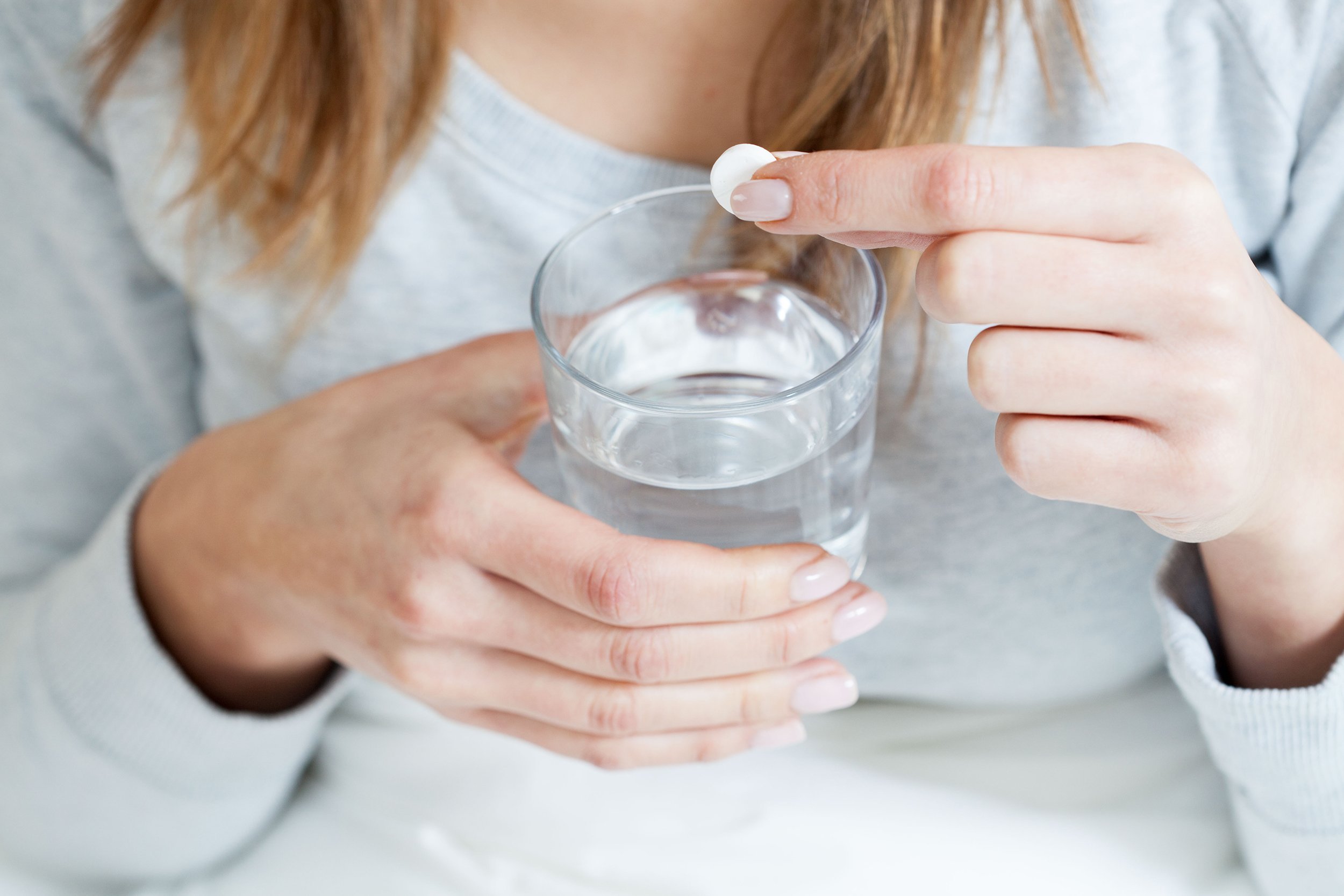 horizontal view of ill woman taking aspirin