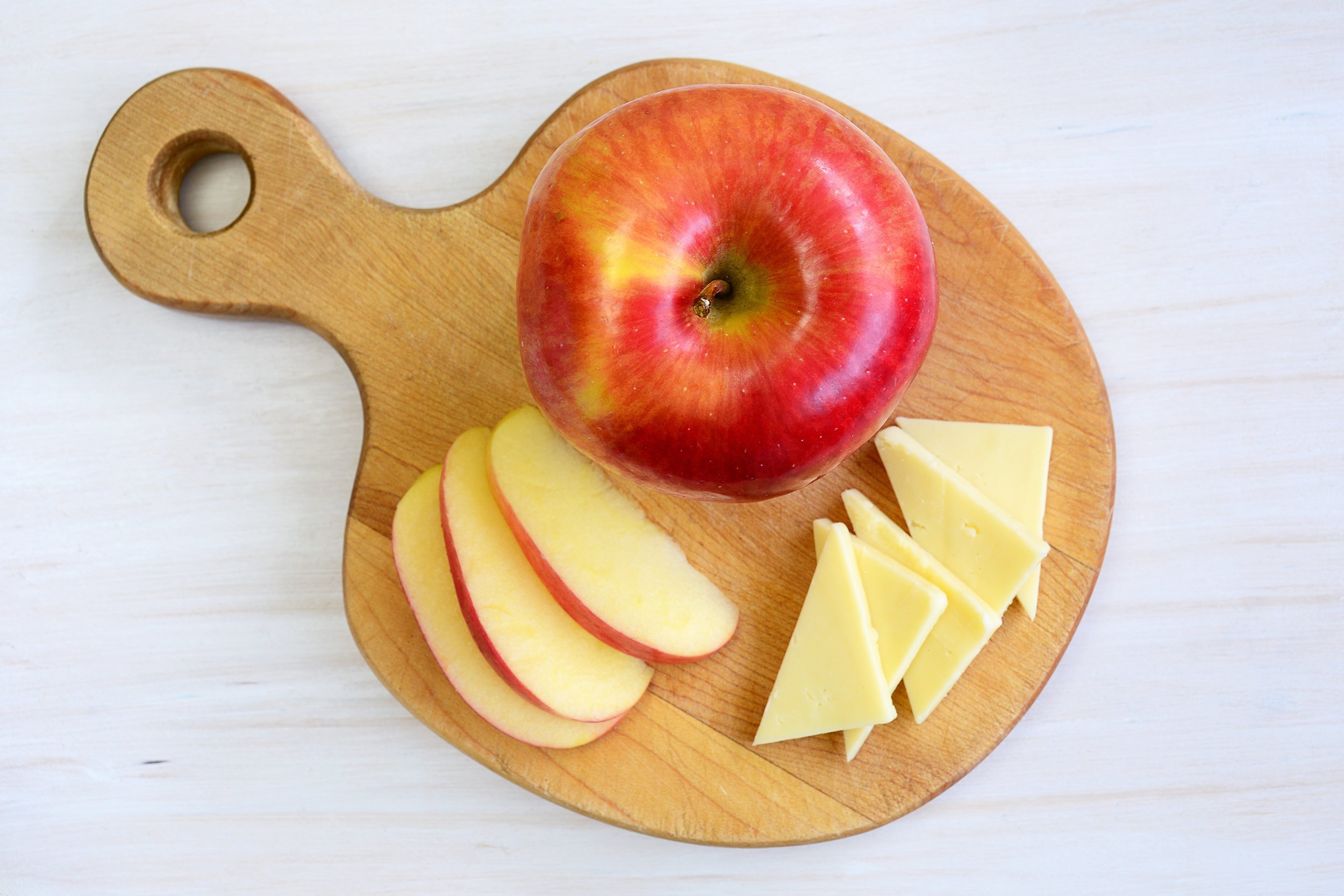honeycrisp apple with cheese on cutting board