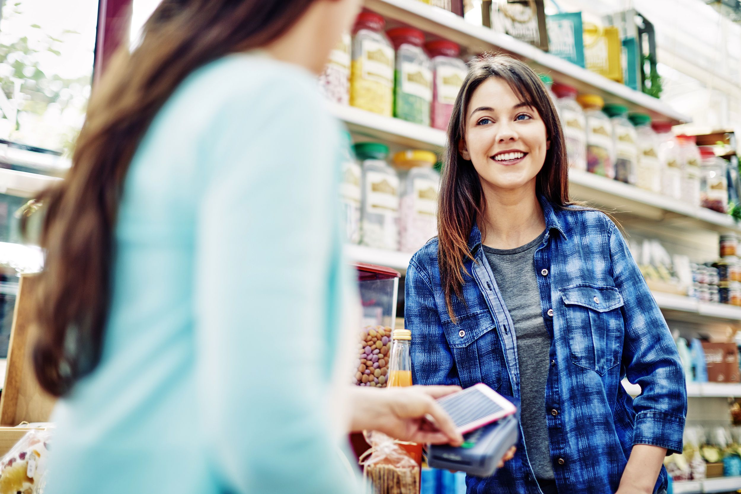 Woman speaking to a cashier at a grocery store