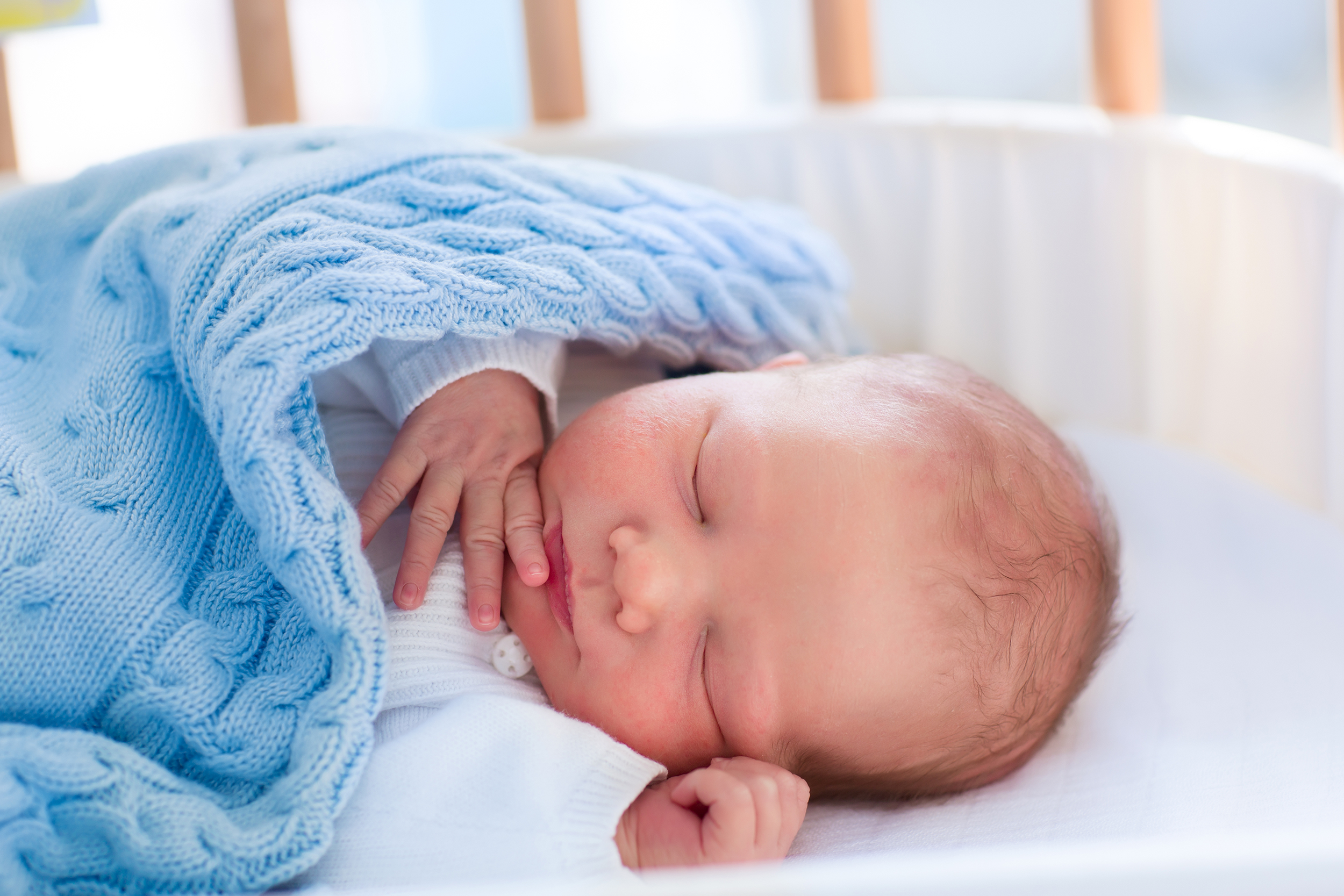 Newborn baby boy sleeping in a crib