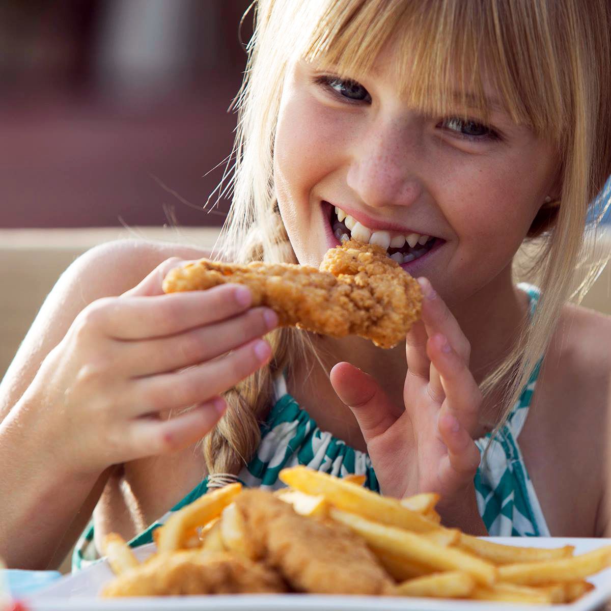 Girl eating chicken strips at Eats Kitchen
