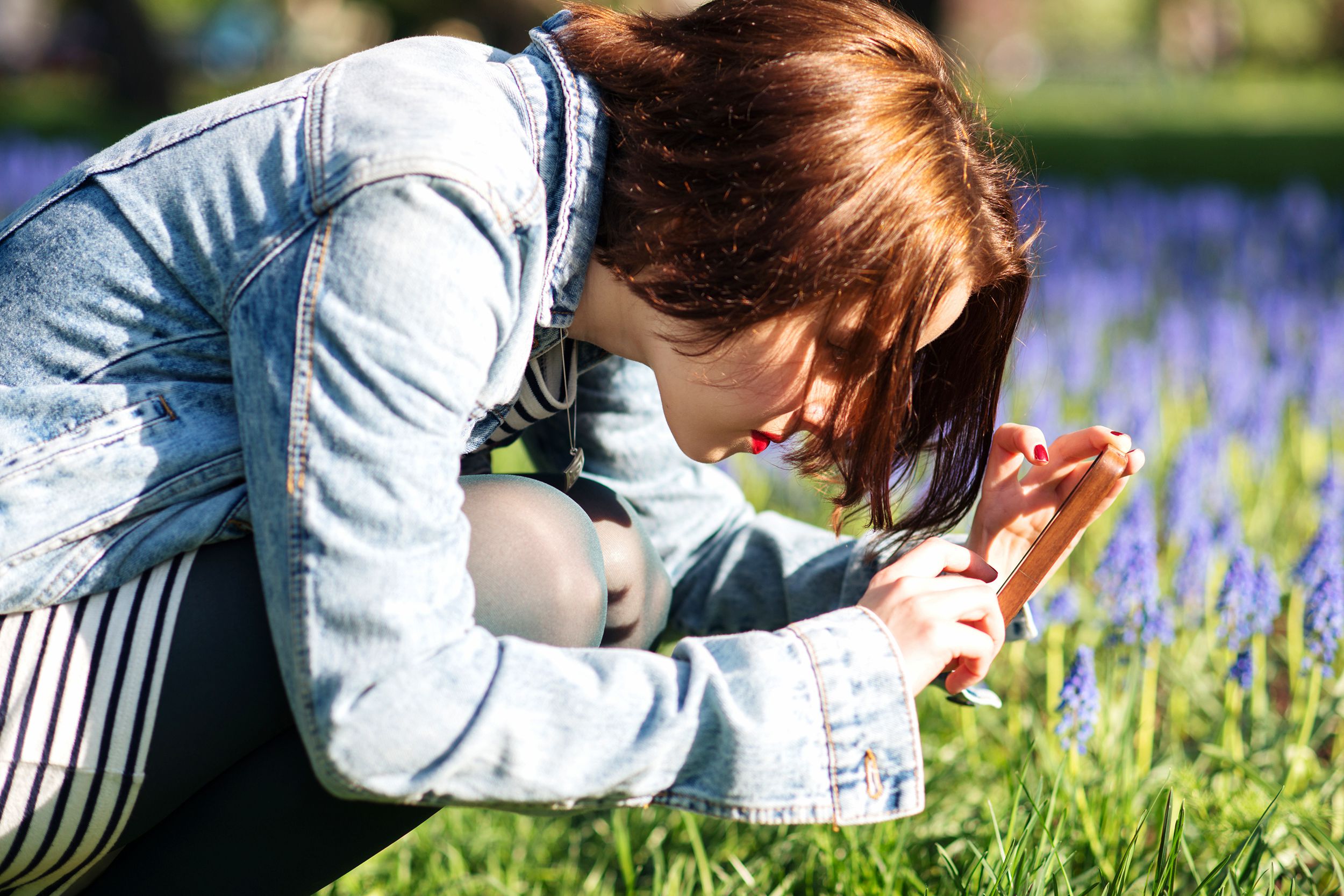 Girl taking a closeup photo of a flower
