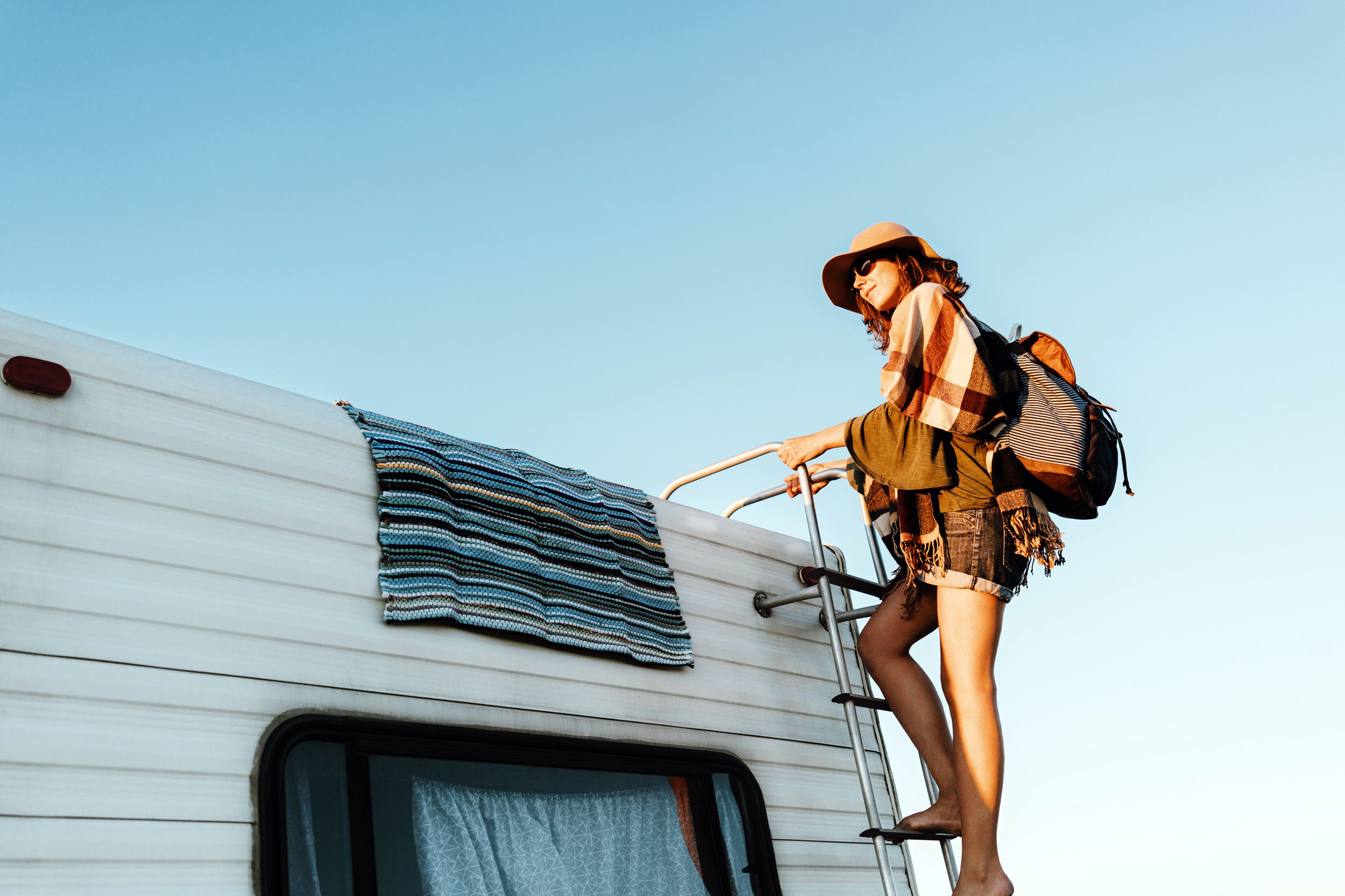 Woman climbing to the roof of an RV