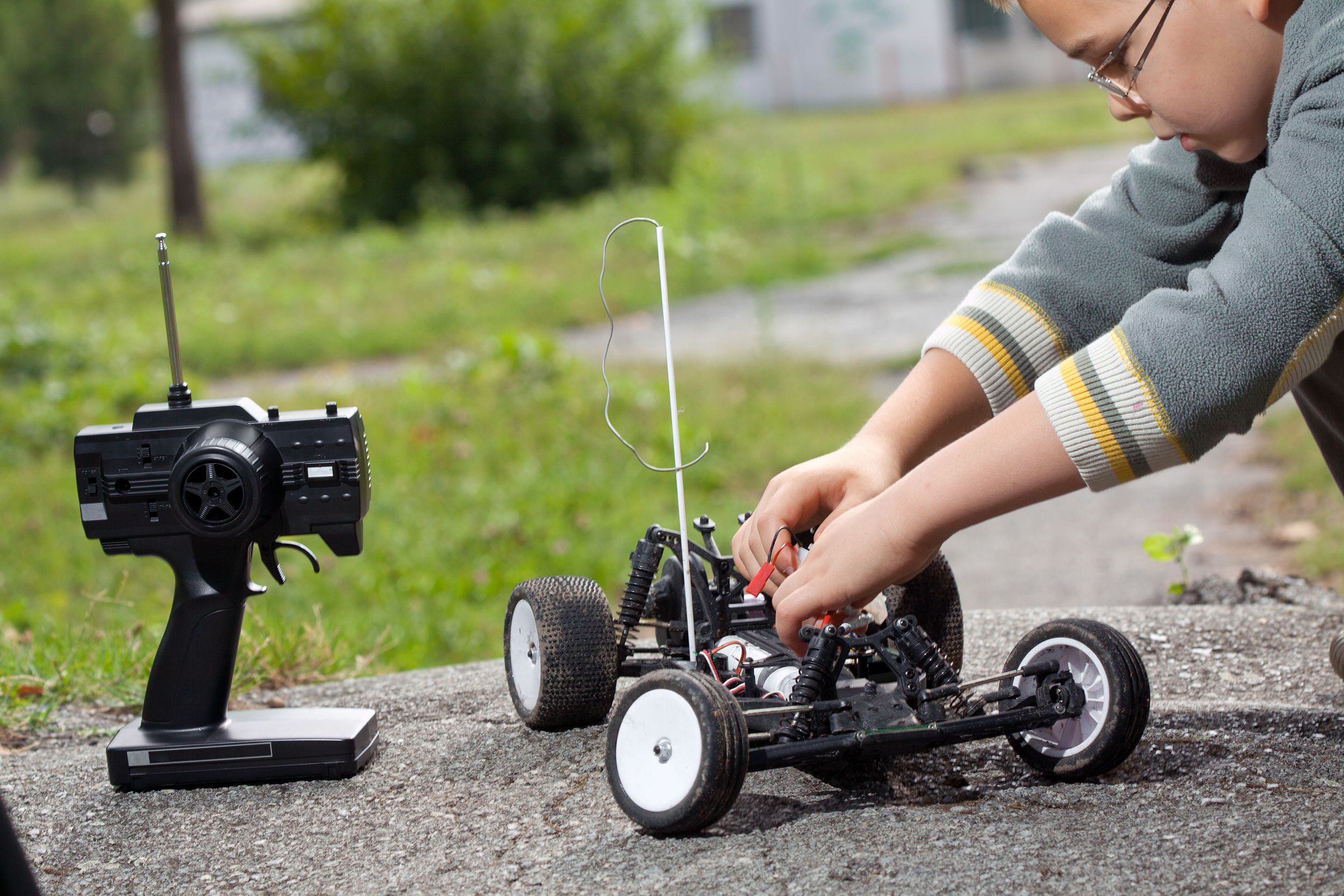 Young boy fixing his remote-controlled vehicle