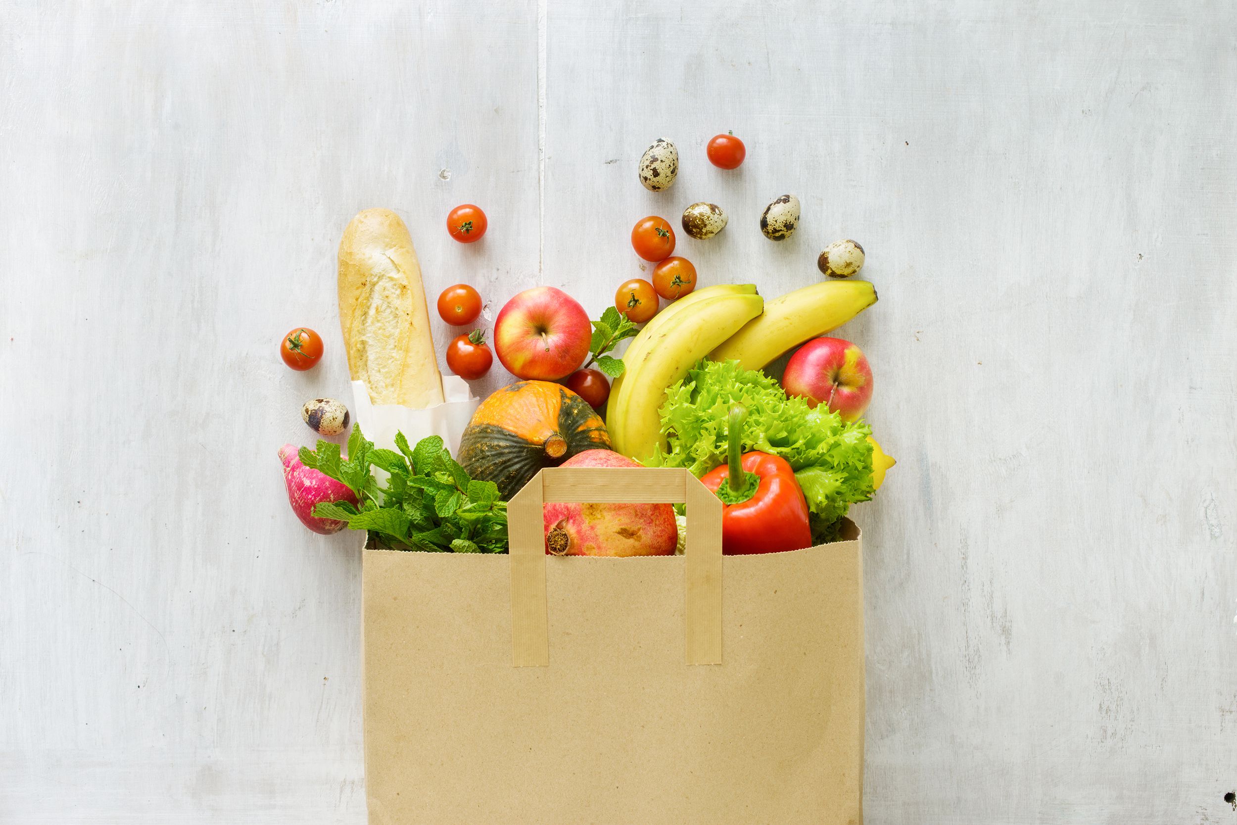Grocery bag on a counter with groceries spilling out