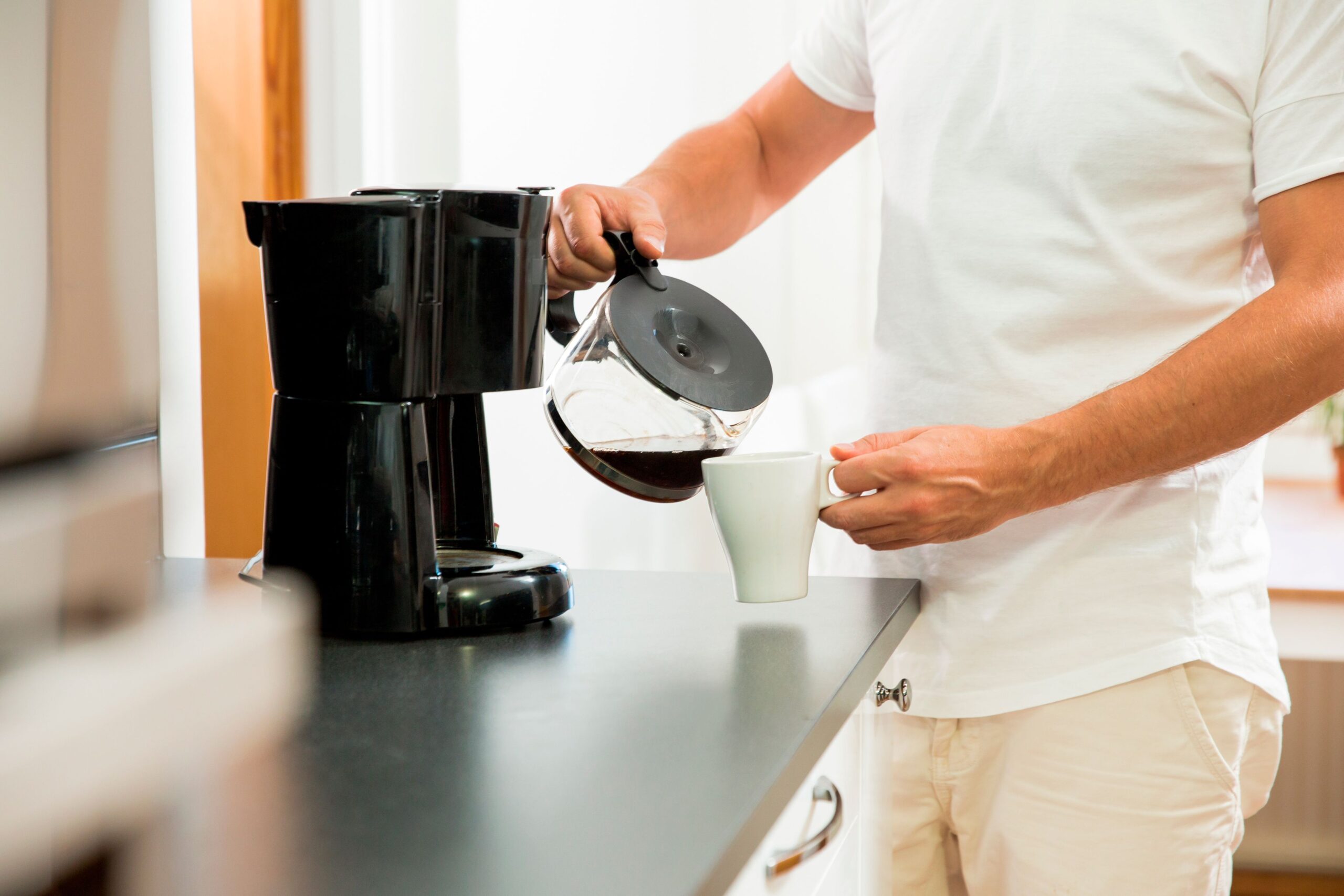 man pouring coffee at home