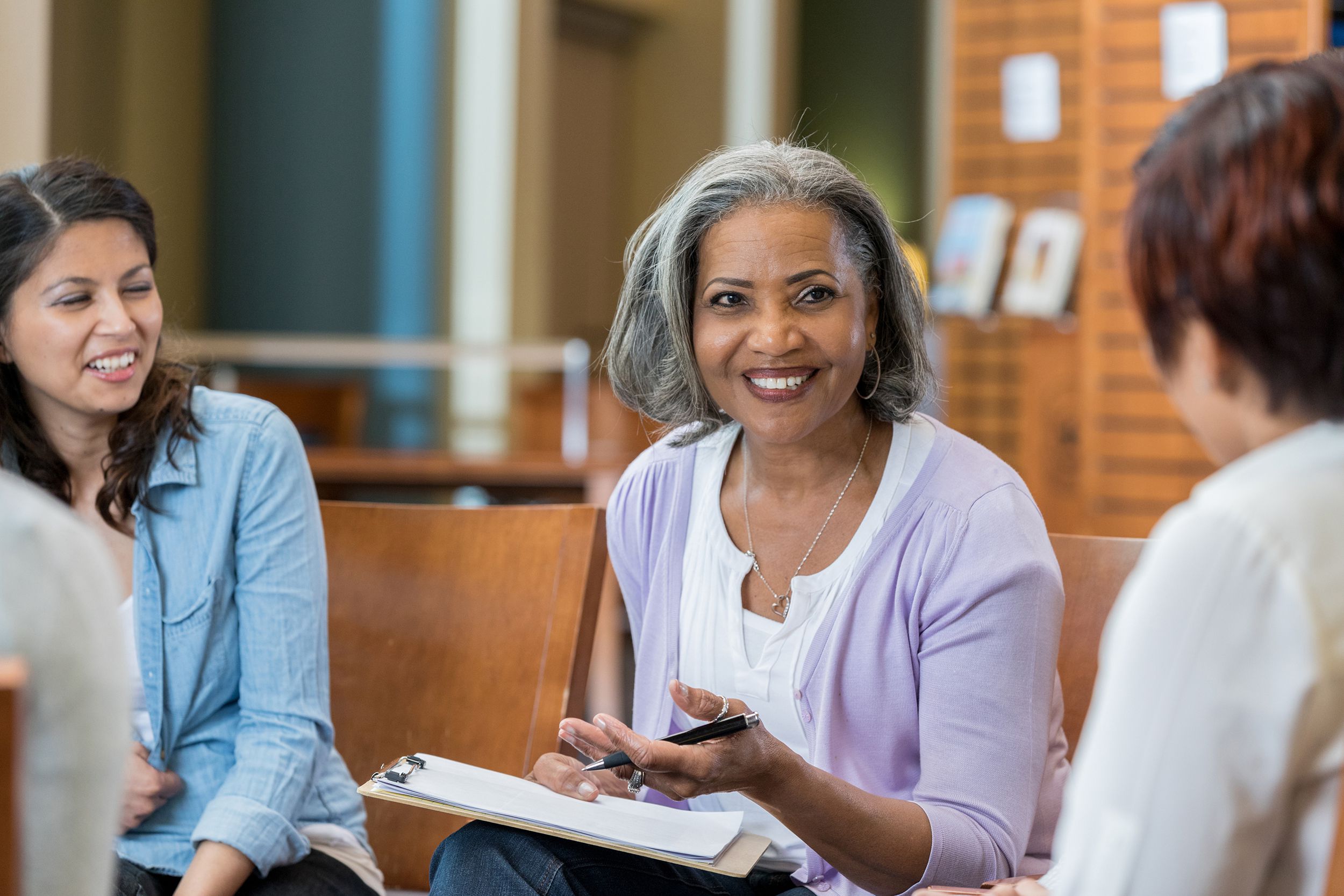 senior female talks with group in casual setting