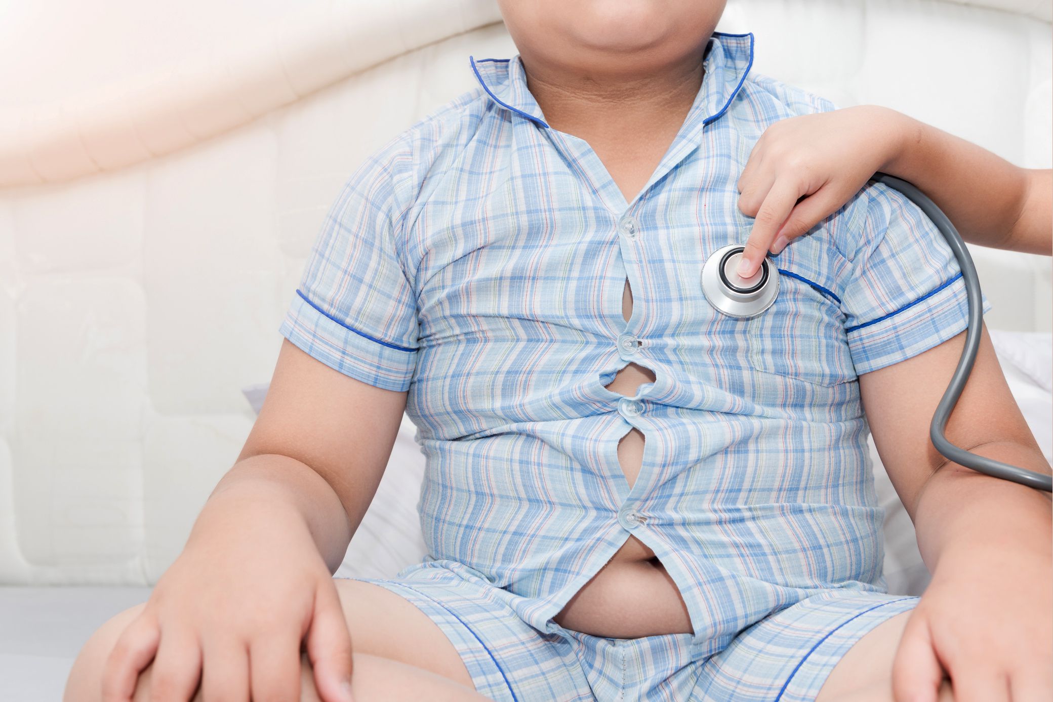 chubby child with shirt buttons popping and stethoscope
