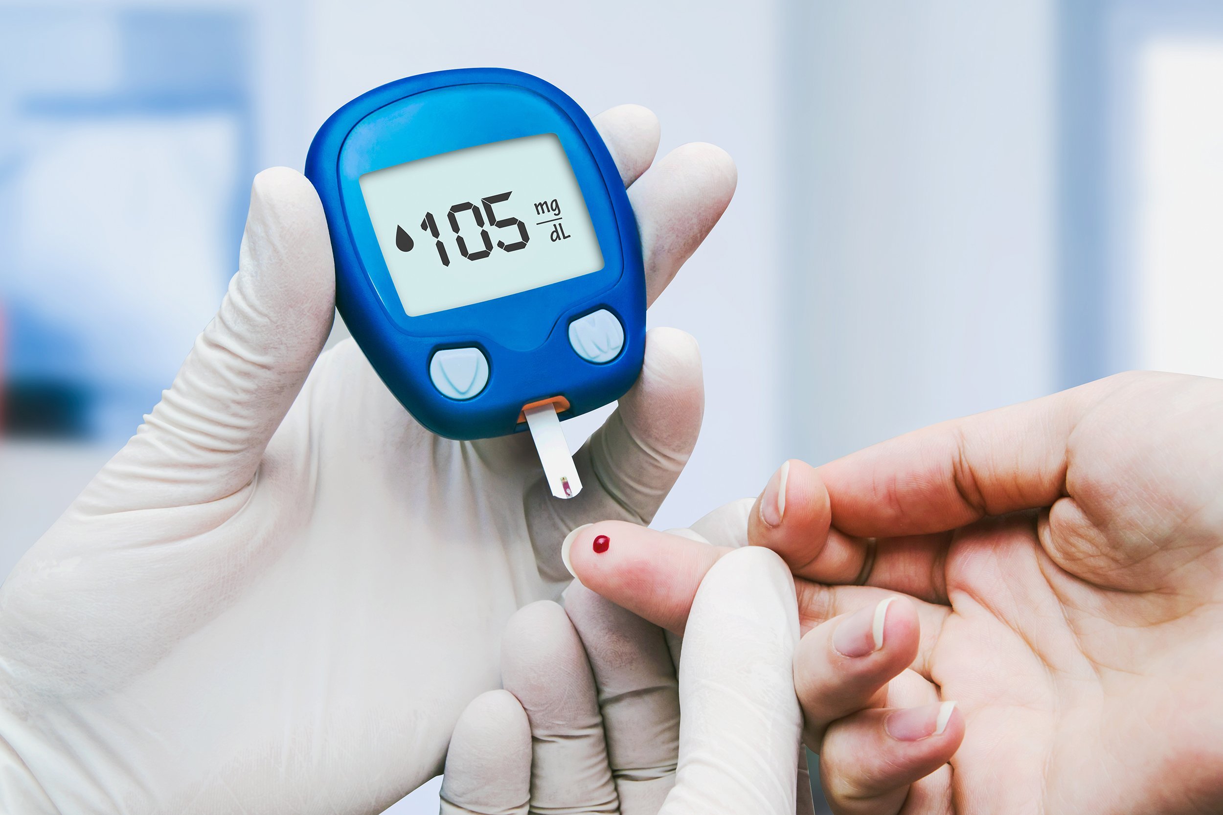 doctor making blood sugar test in clinic for diabetes