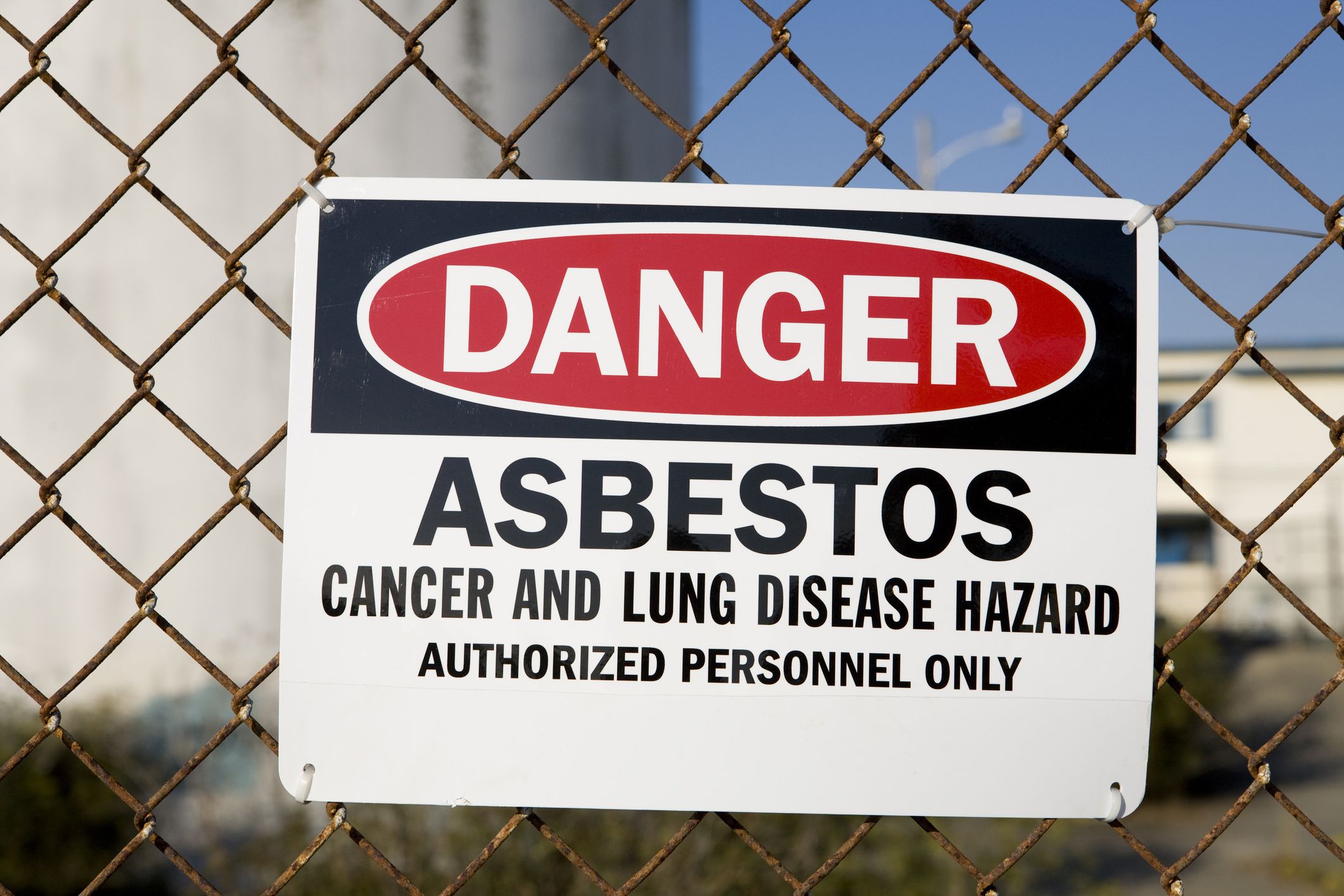 danger asbestos sign attached to fence