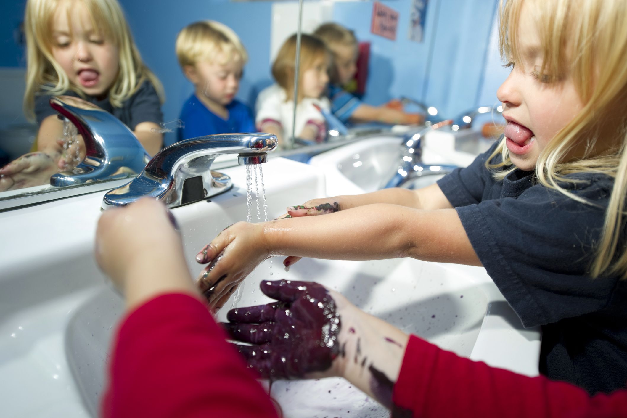 children washing their hands in hallway