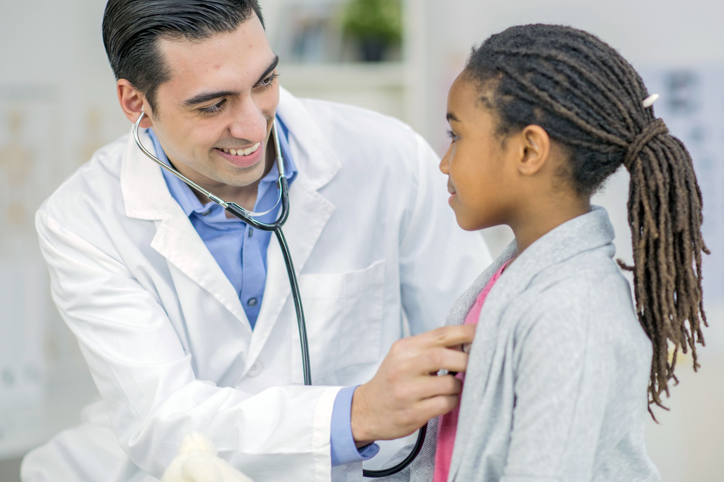 doctor checking heart of African American girl