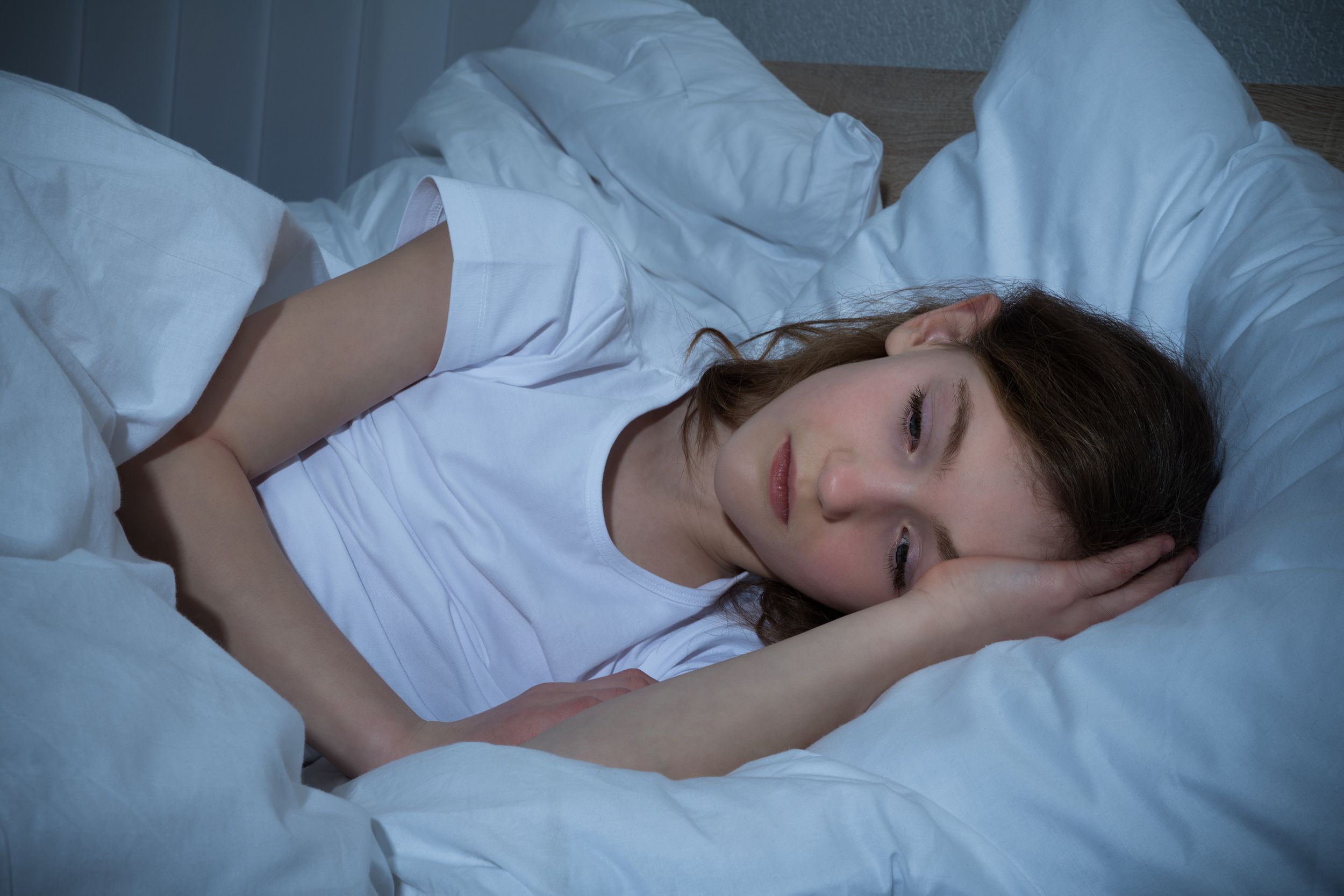 girl laying in bed unable to sleep