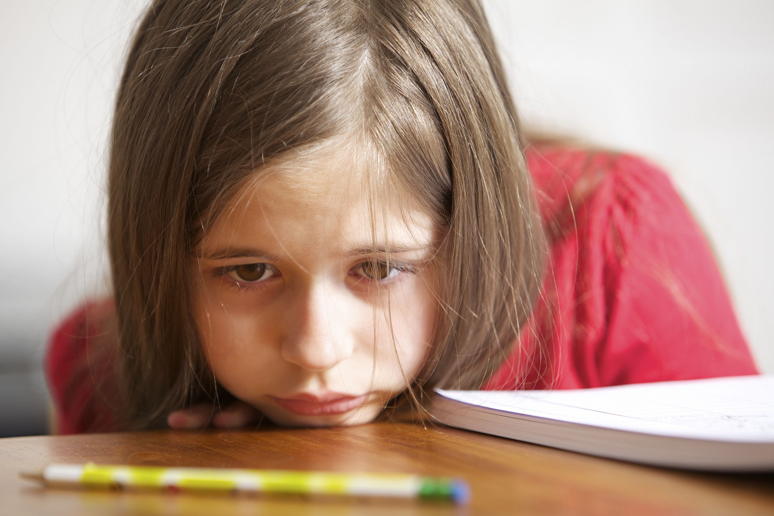 sad little girl at desk