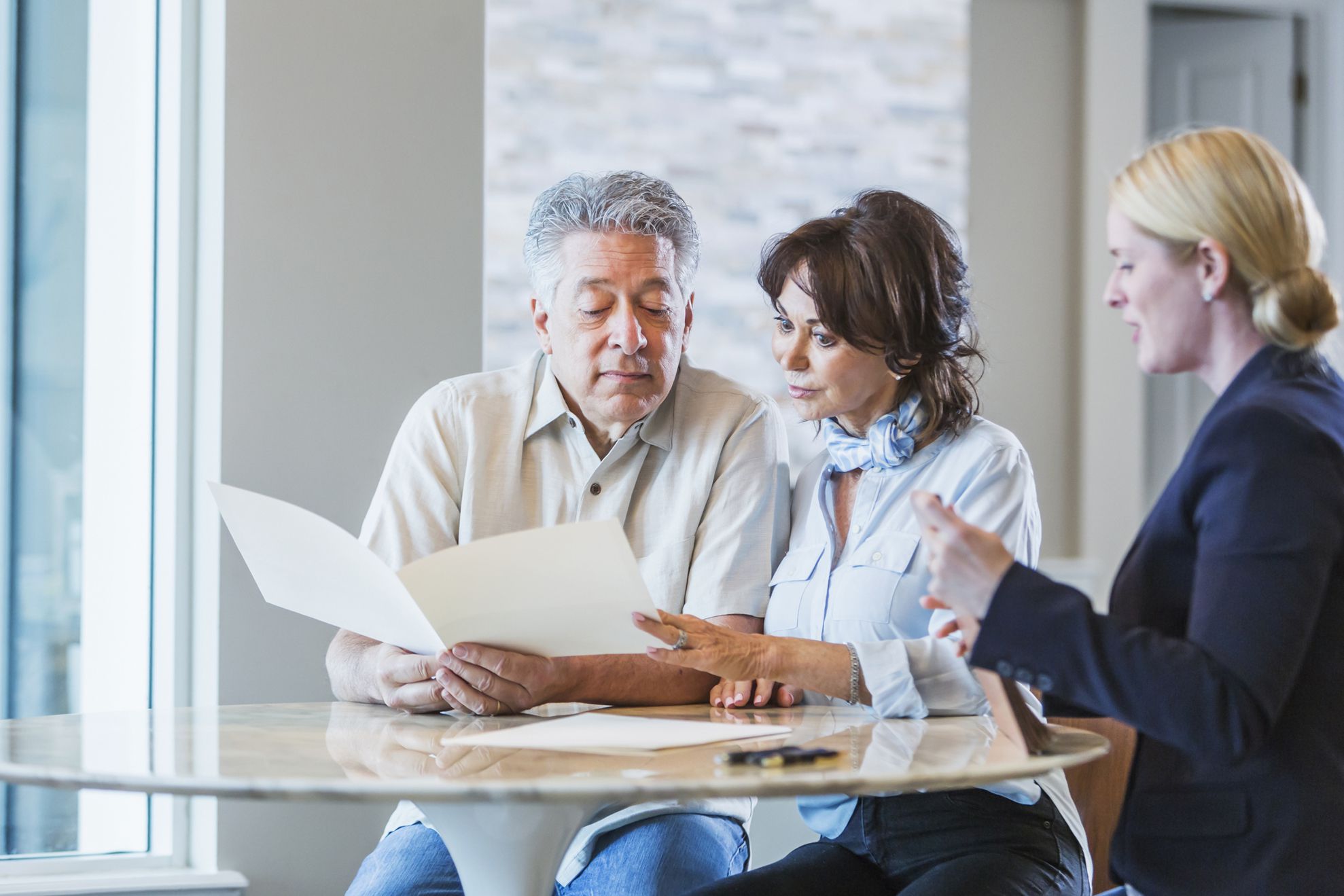 senior couple looking at bank promotional offer with financial assistant