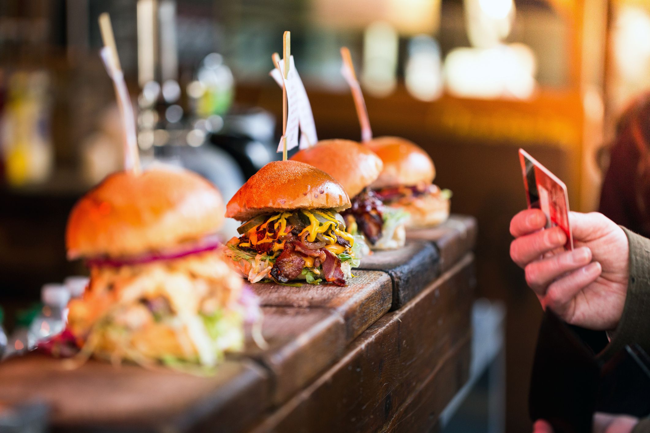 close-up of hand holding credit card to pay for burgers