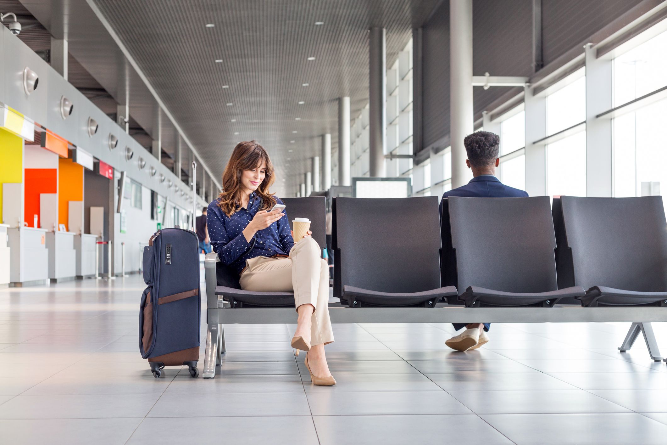 relaxed woman smiling sitting at airport gate
