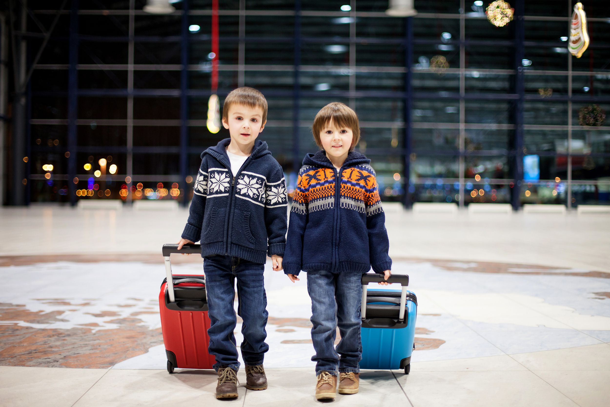 Little boys at an airport at night during Christmas time