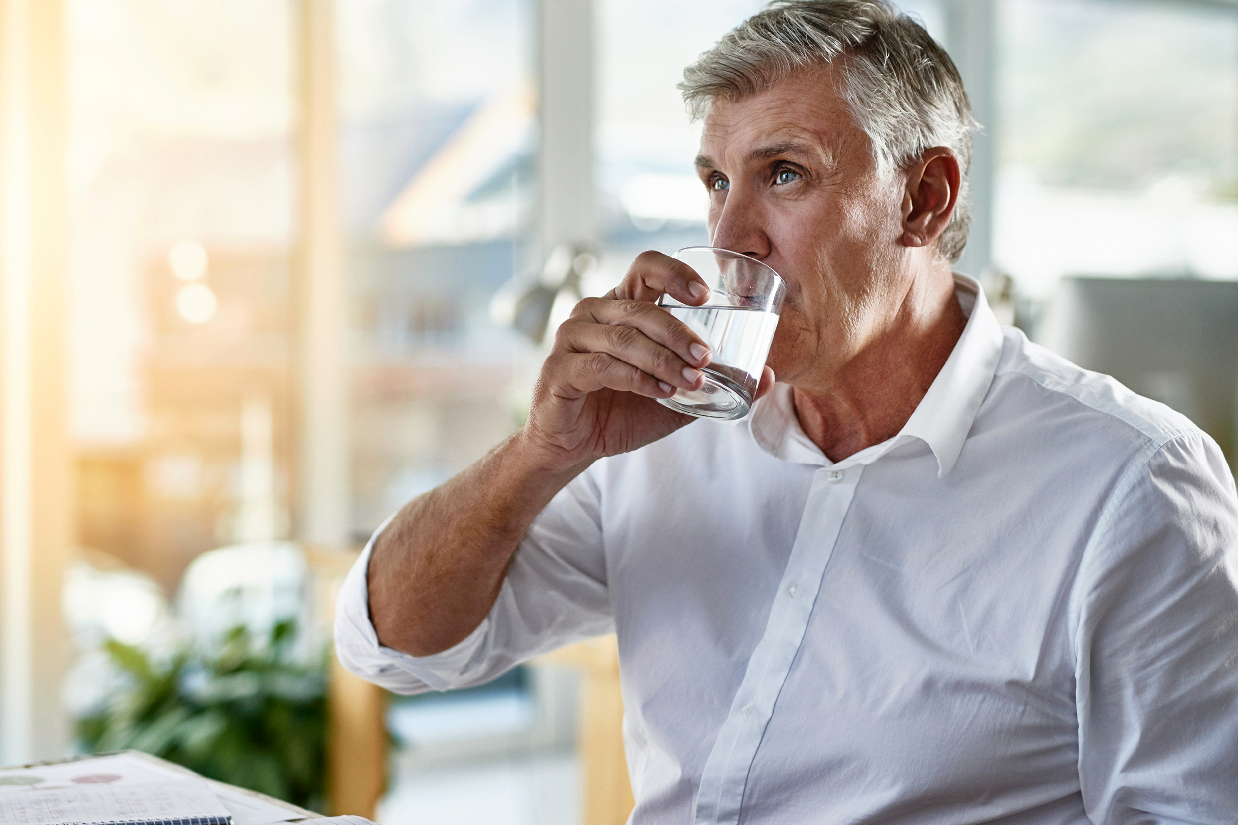 Man drinking water at his desk