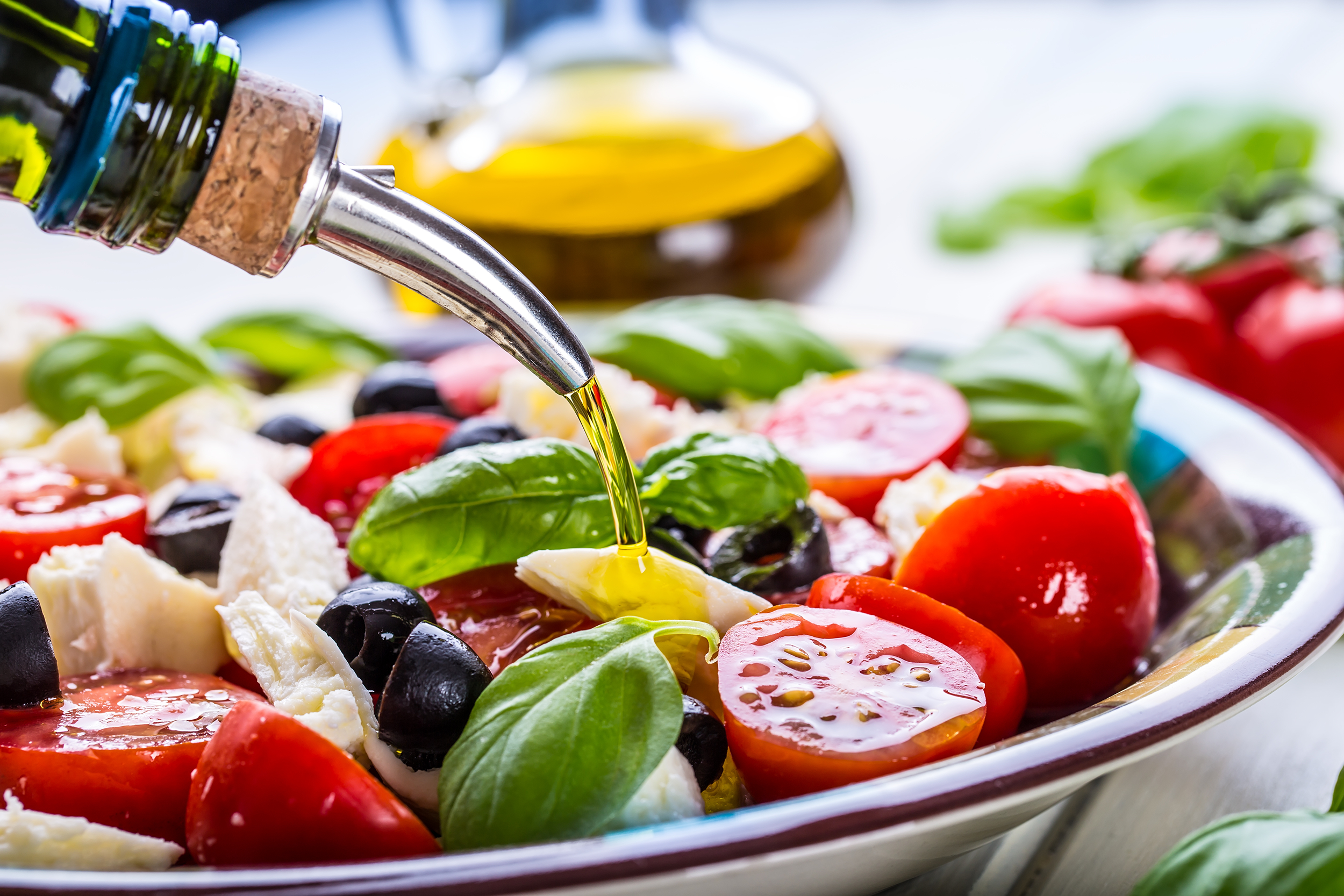 Pouring olive oil on salad