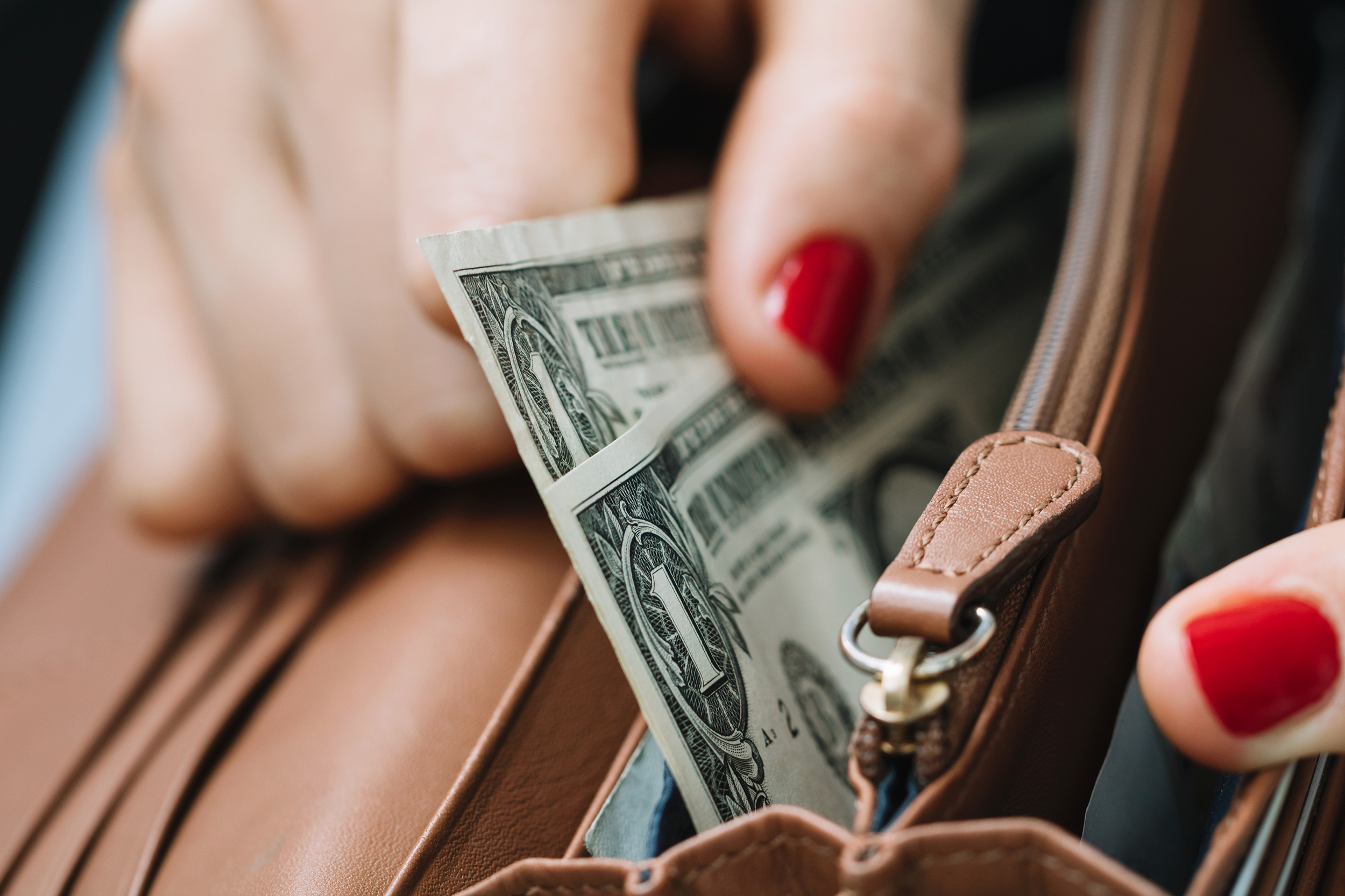 Woman's hands getting money out of a wallet