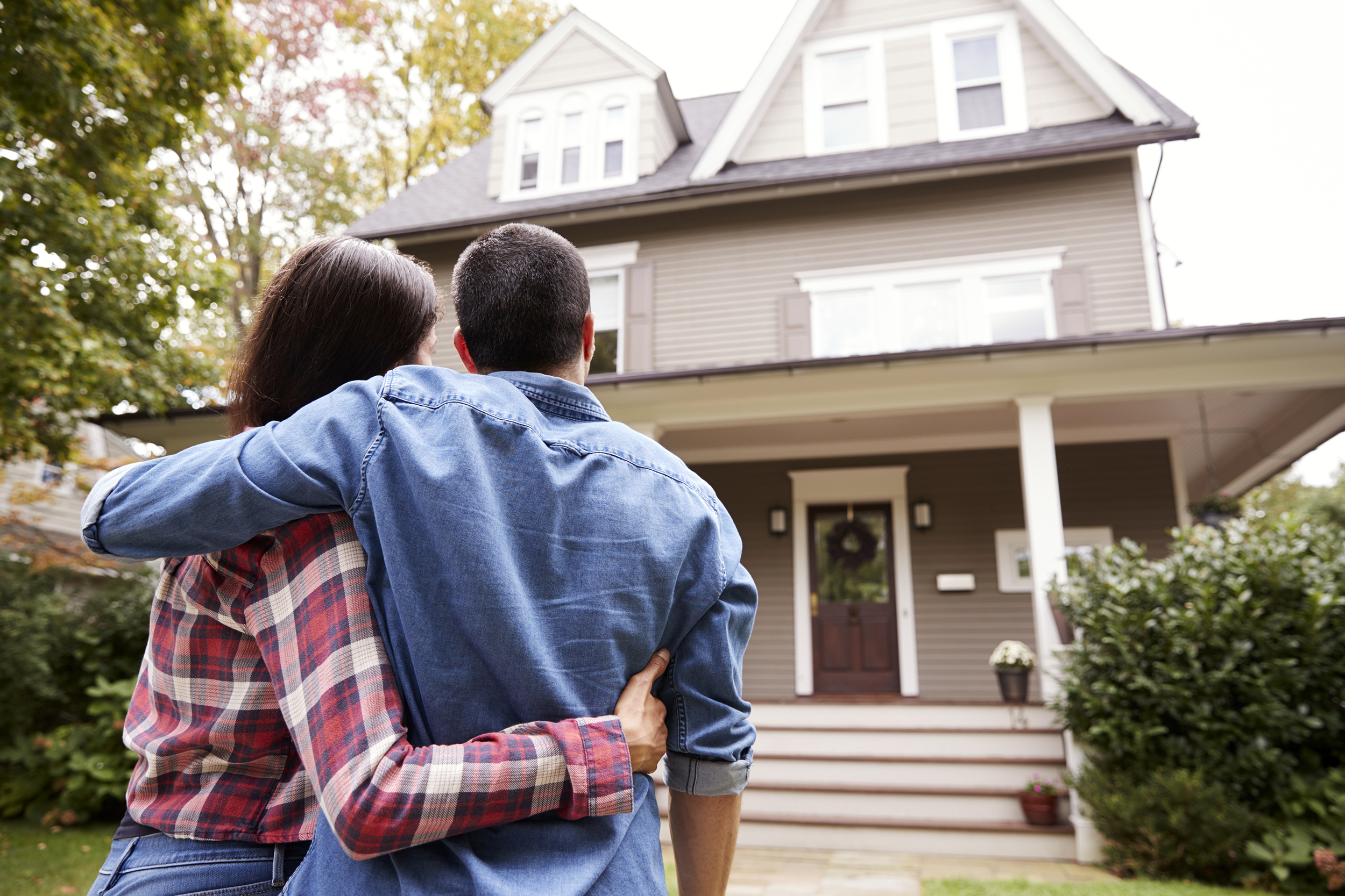 Couple standing outside looking at a new house
