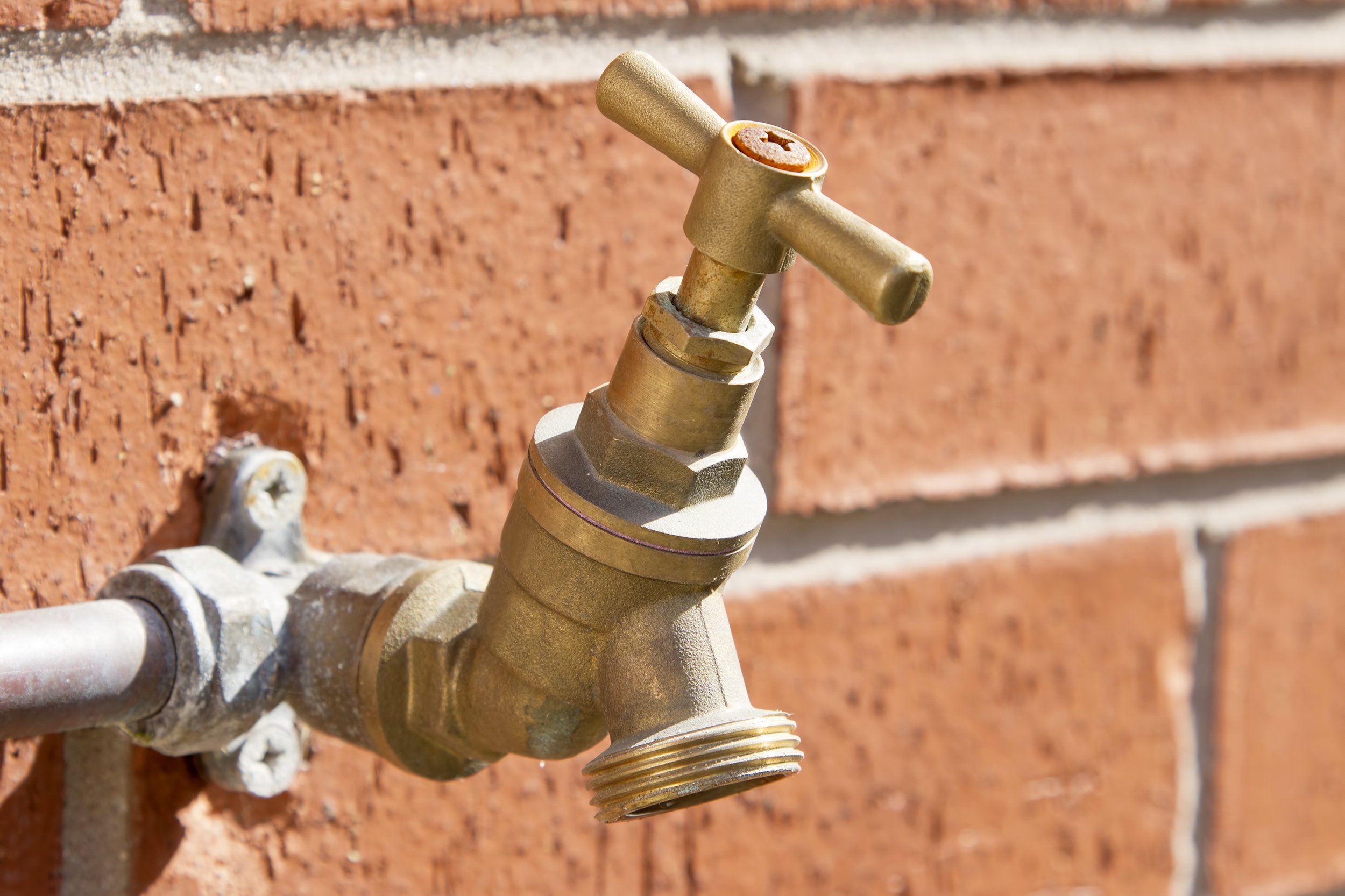outside tap on brick wall