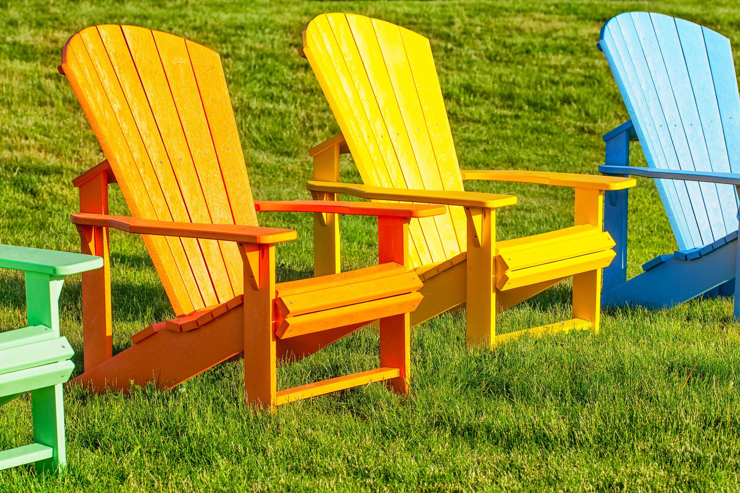 colorful painted Adirondack chairs on green grass